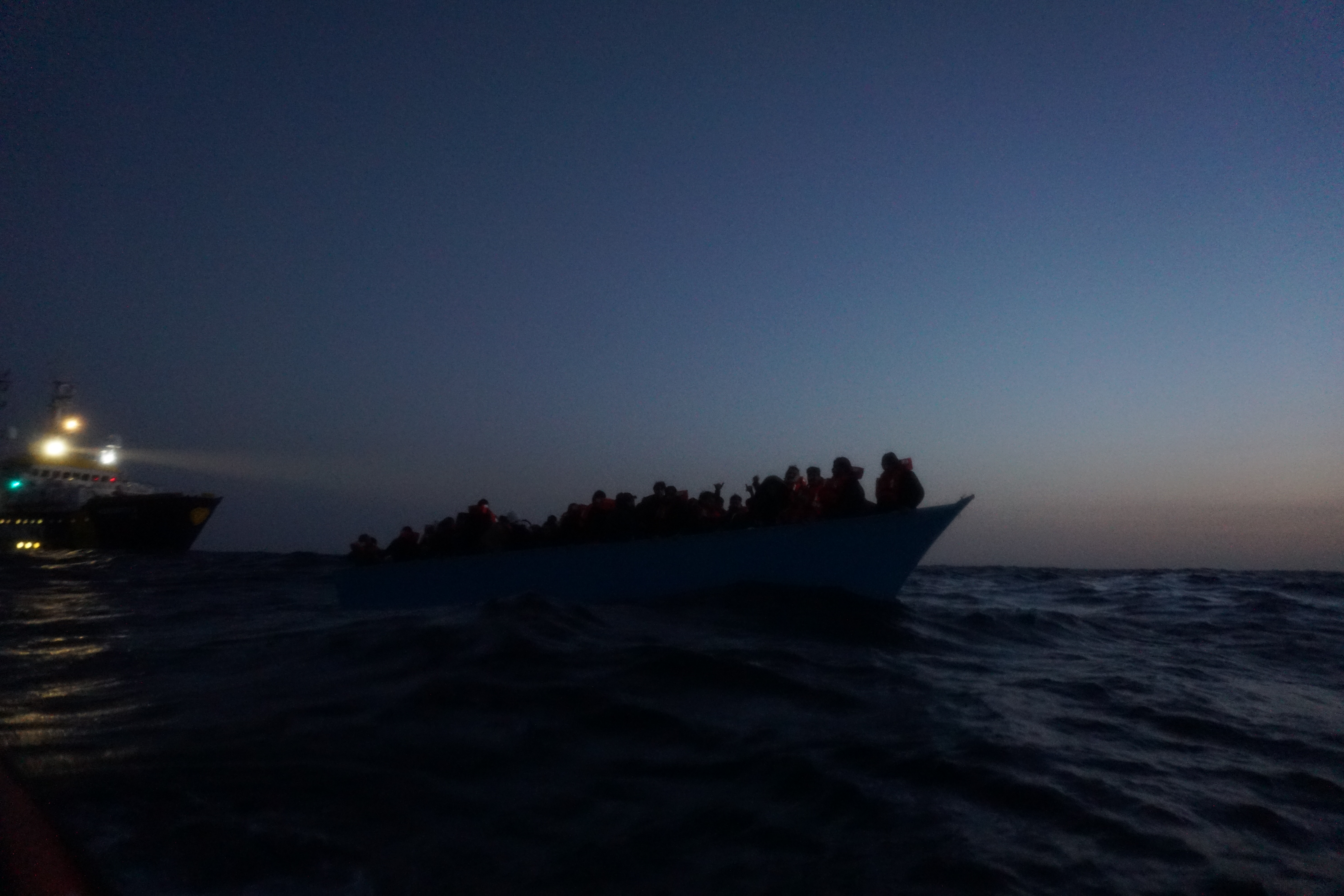 boat in distress against barely light sky