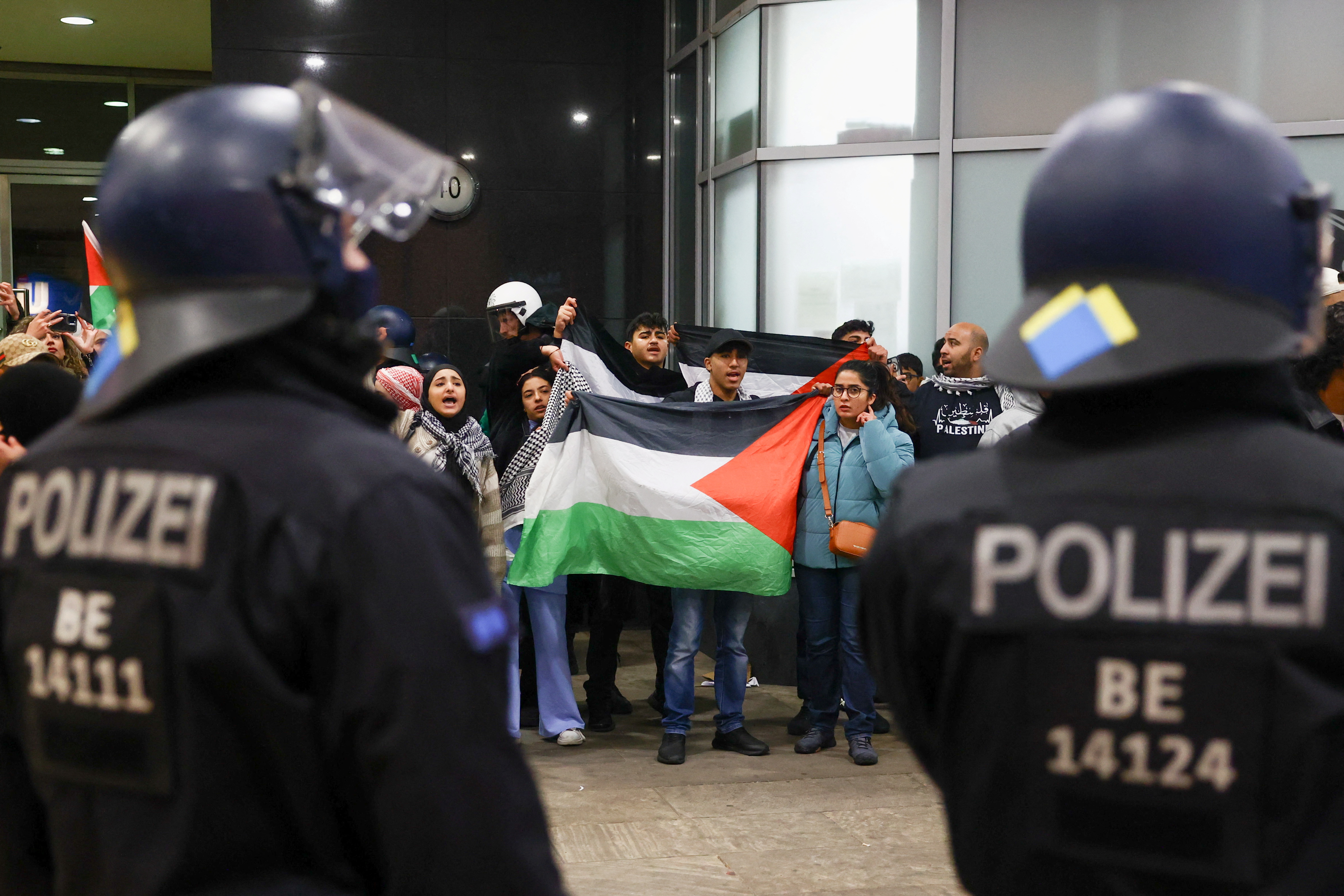 People hold Palestinian flags as pro-Palestinian demonstrators protest in front of police officers during the ongoing conflict between Israel and the Palestinian Islamist group Hamas, in Berlin, Germany October 15, 2023. REUTERS/Christian Mang