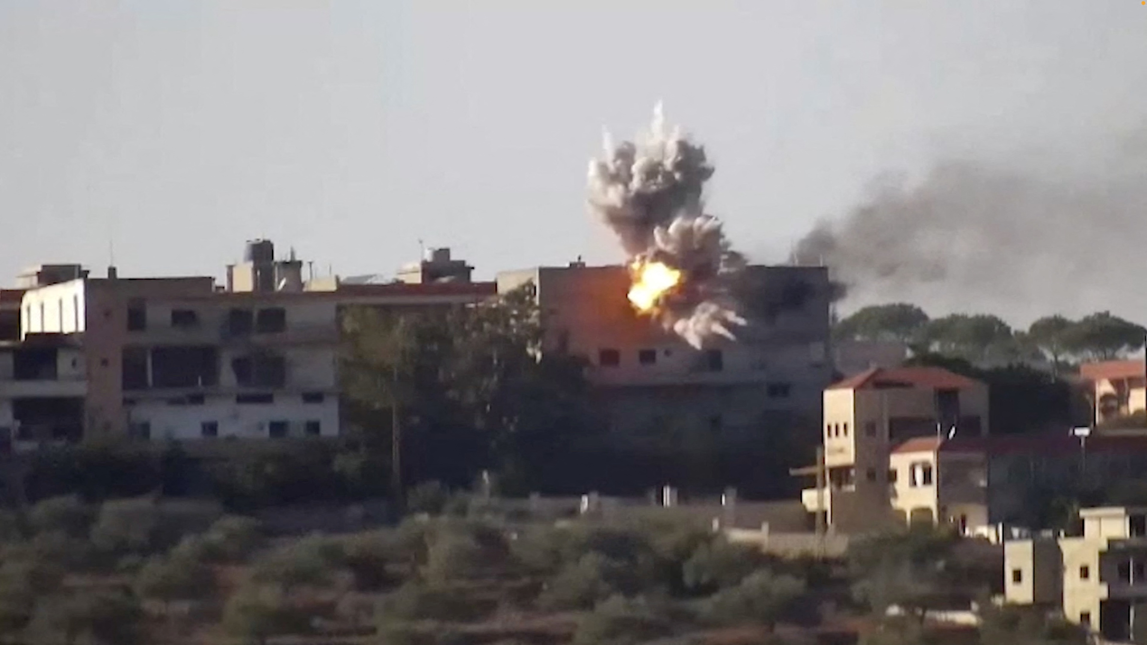 Smoke and fire rise from a building following an Israeli strike on what the Israeli military says are Hezbollah targets in a location given as Lebanon, amid the ongoing cross-border hostilities between Hezbollah and Israeli forces, in this screengrab taken from an undated handout video released on November 24, 2023.