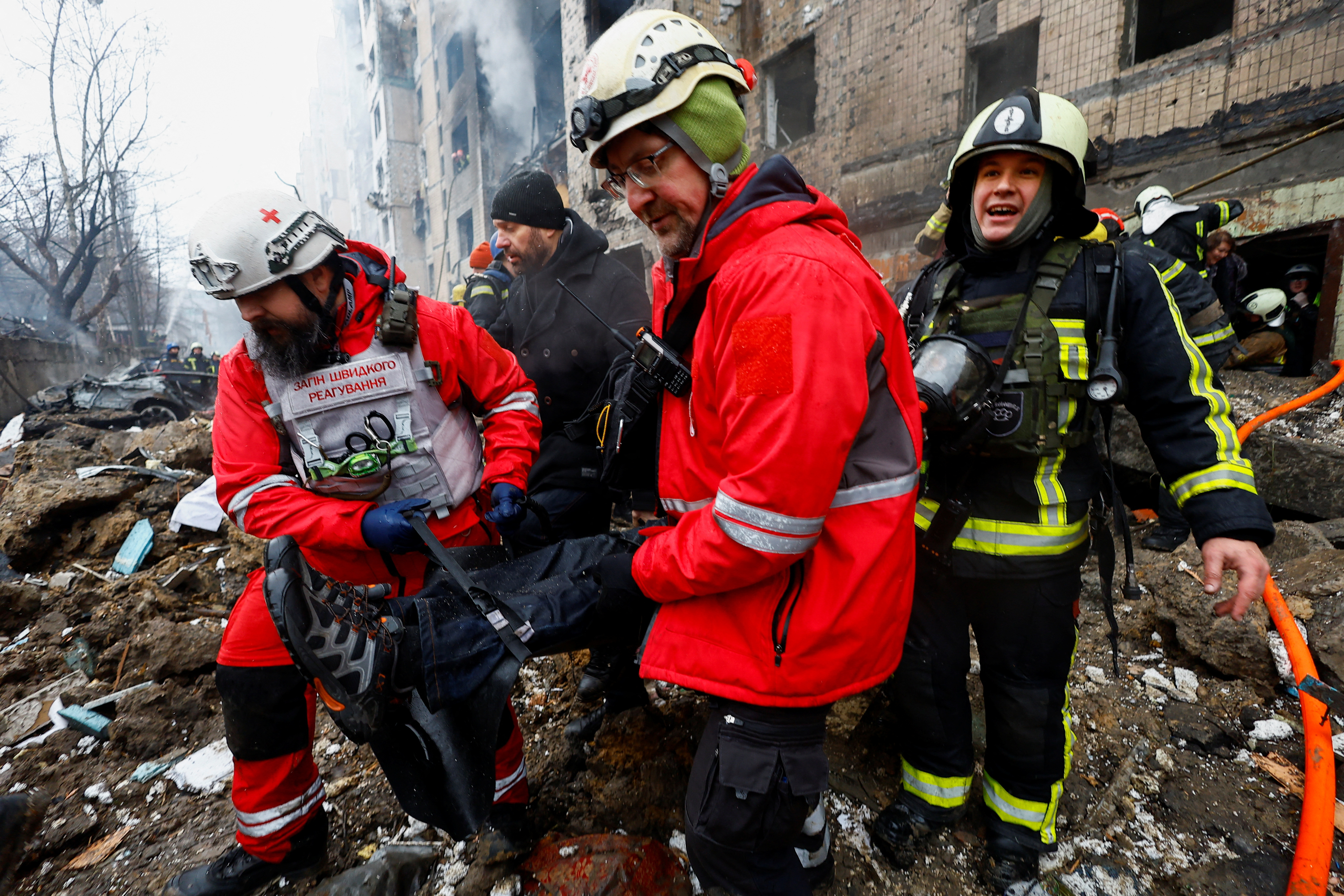 Firefighters rescue a local resident from a site of a residential building heavily damaged during a Russian missile attack, amid Russia's attack on Ukraine, in Kyiv