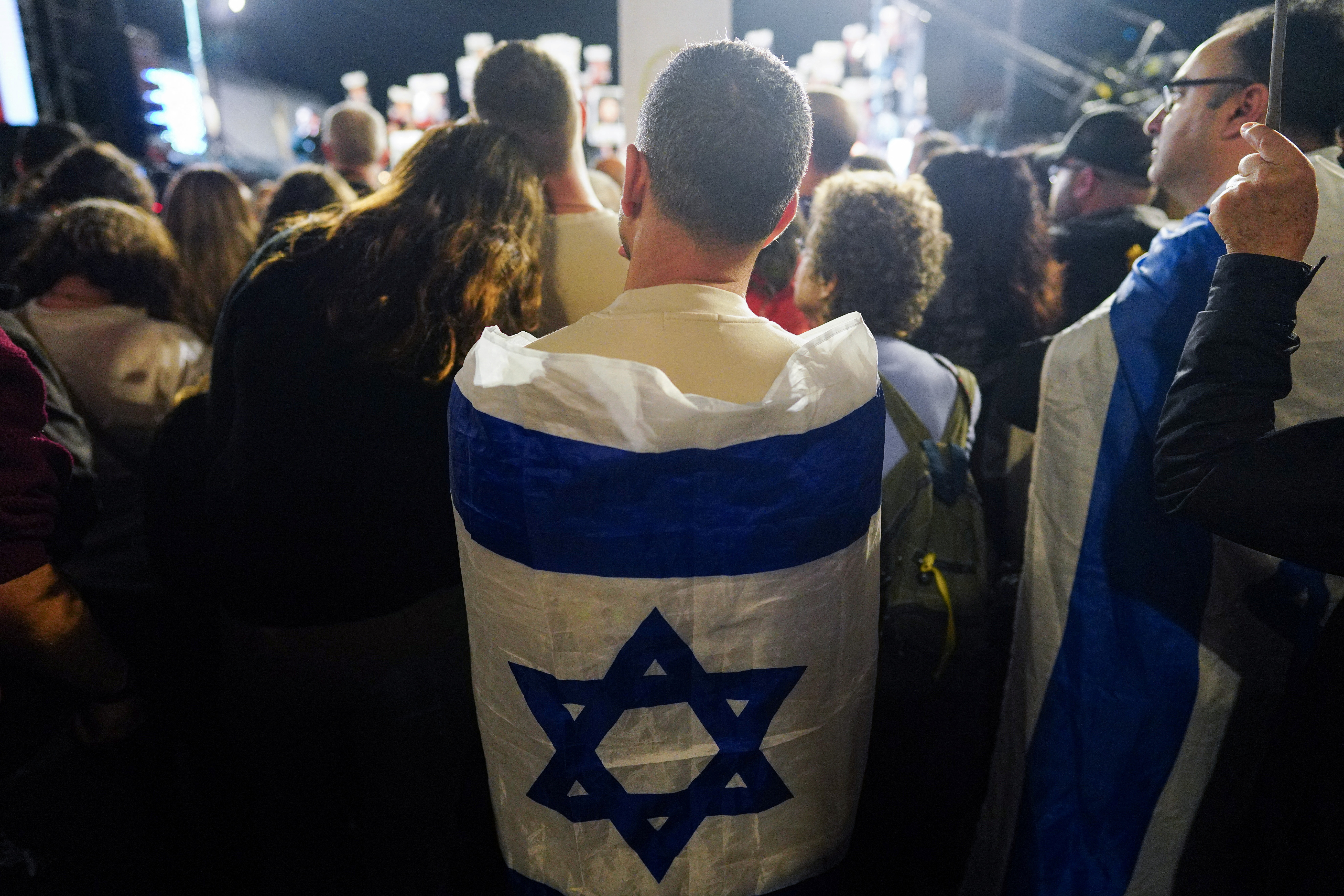 Men wrapped in Israeli flags attend a protest of supporters and families of hostages calling for the release of hostages kidnapped on the deadly October 7 attack by Palestinian Islamist group Hamas, in Tel Aviv, Israel