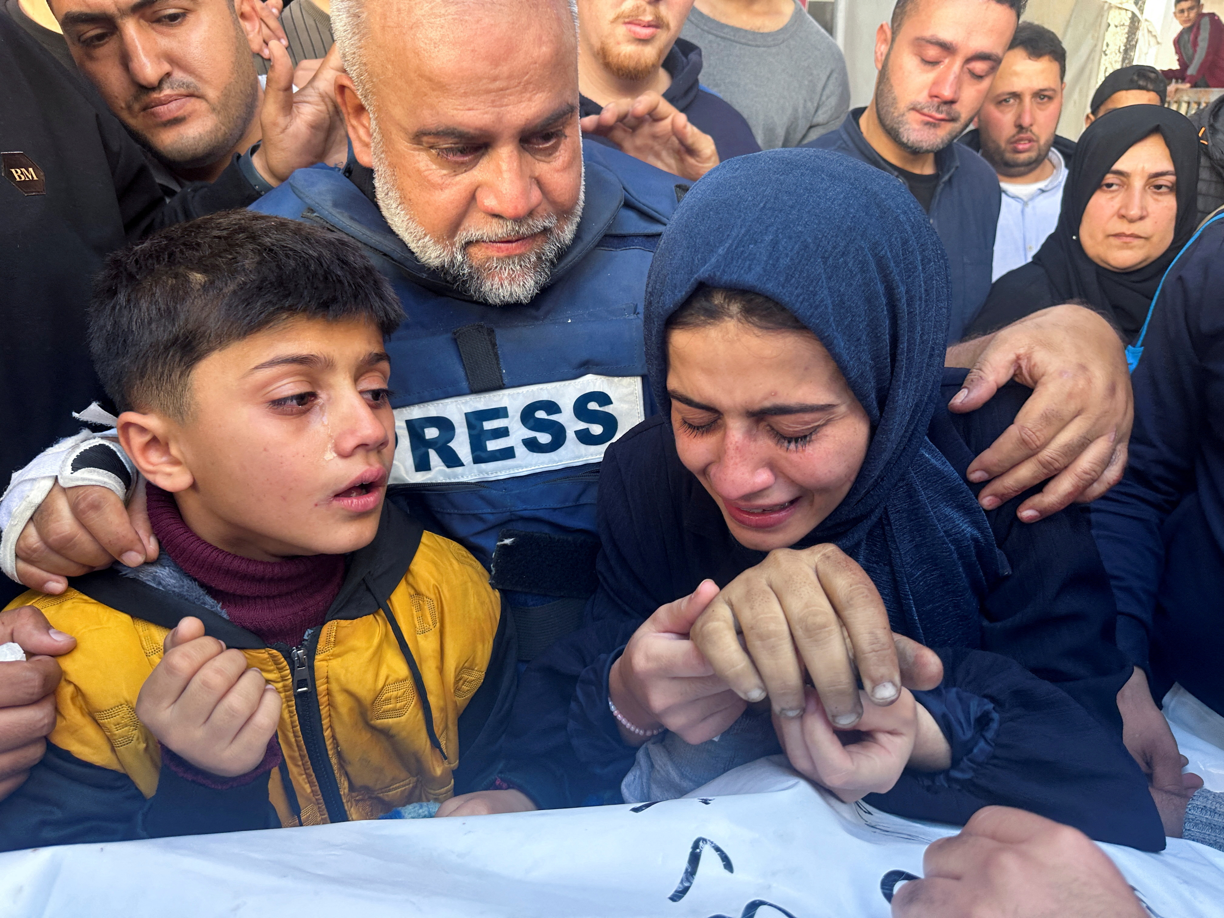 Al Jazeera journalist Wael Dahdouh hugs his daughter and son as they attend the funeral of his son Hamza, also a journalist, after he was killed in an Israeli attack
