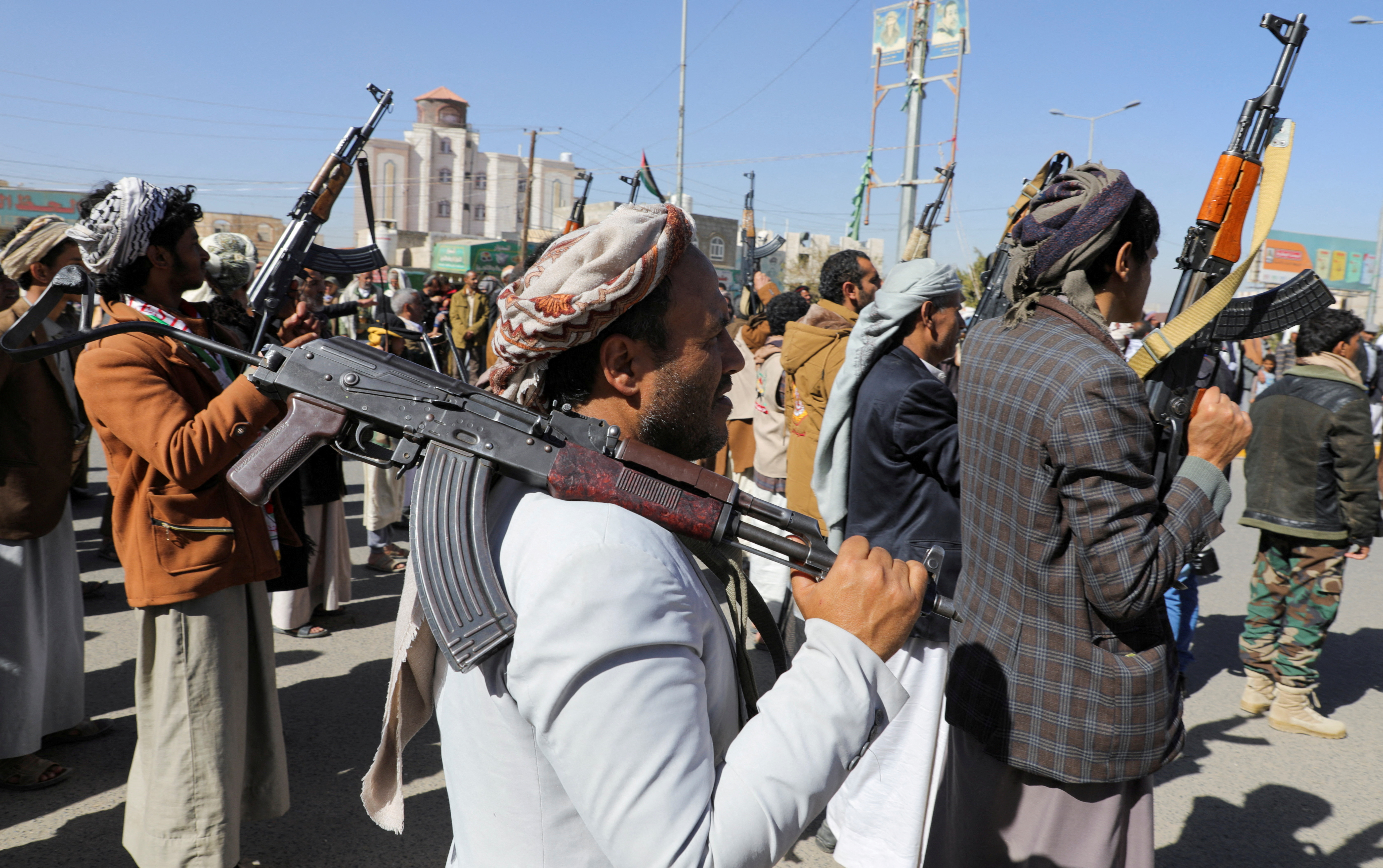 Newly recruited Houthi fighters hold up firearms