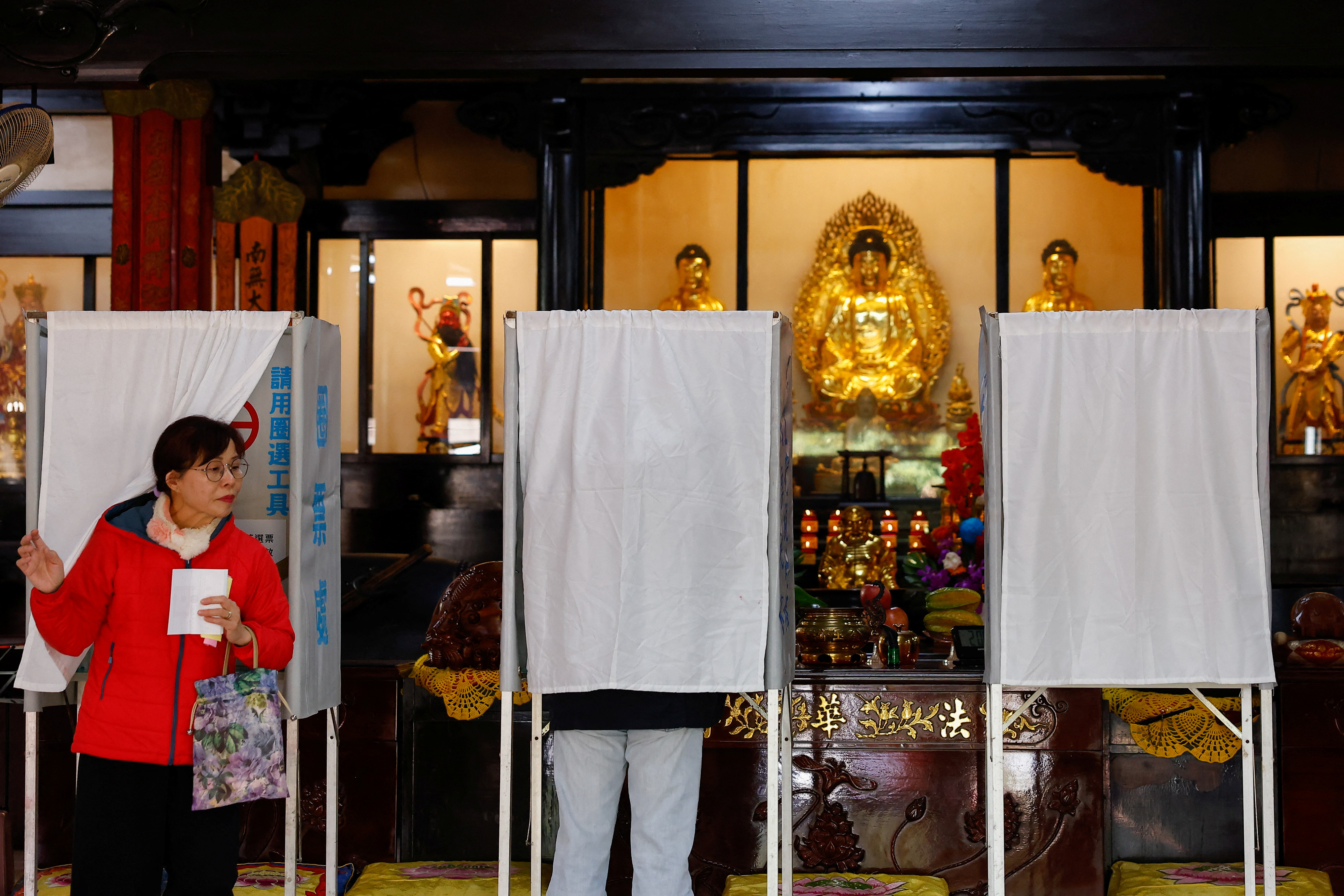 A woman prepares to cast her ballot at a polling station during the presidential and parliamentary elections in Taipei