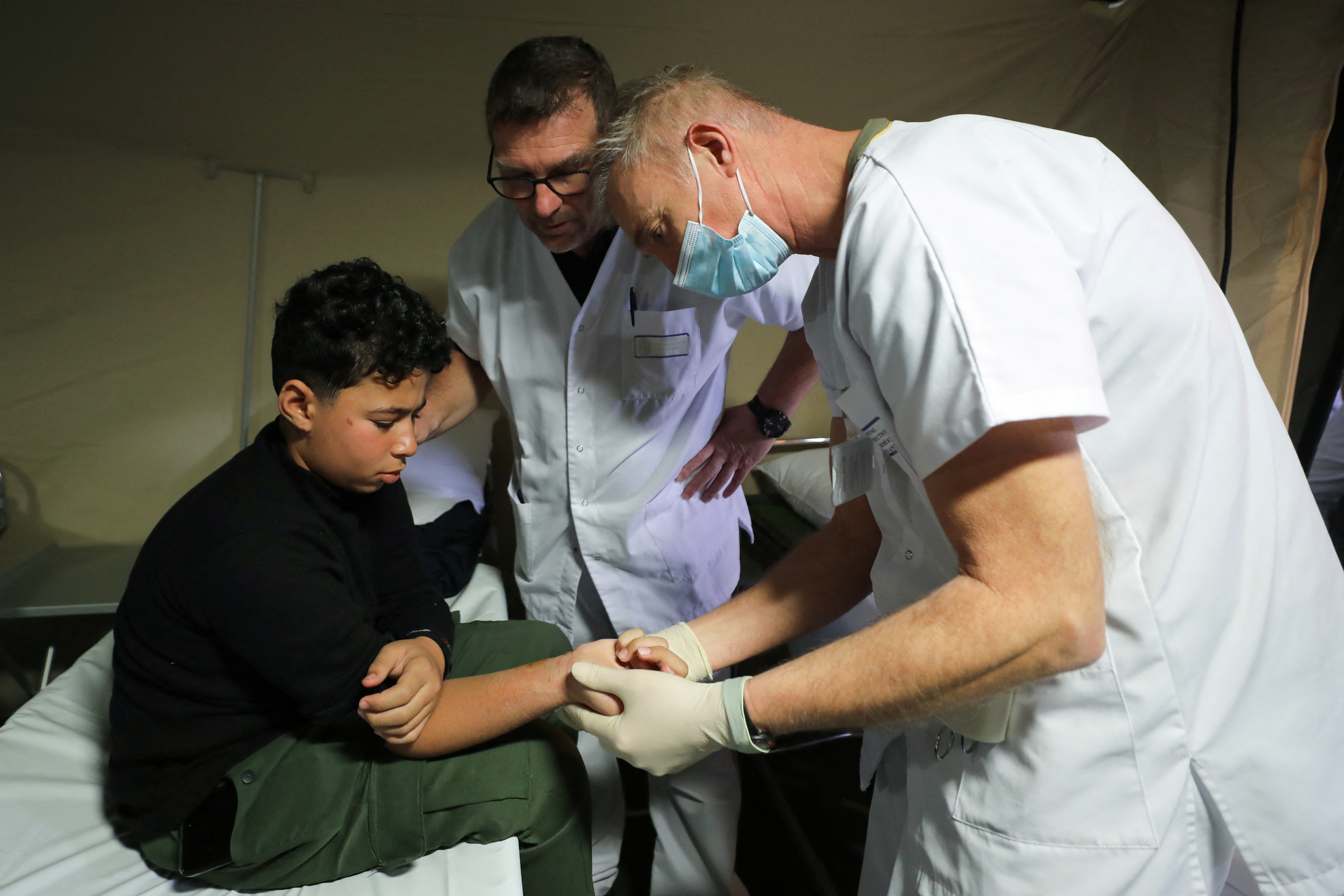 A Palestinian boy sits on a bed as he receives treatment at the hospital onboard the French ship amphibious helicopter carrier Dixmude as it docks, amid the ongoing conflict between Israel and the Palestinian Islamist group Hamas, in the city of Al-Arish, Sinai peninsula, Egypt
