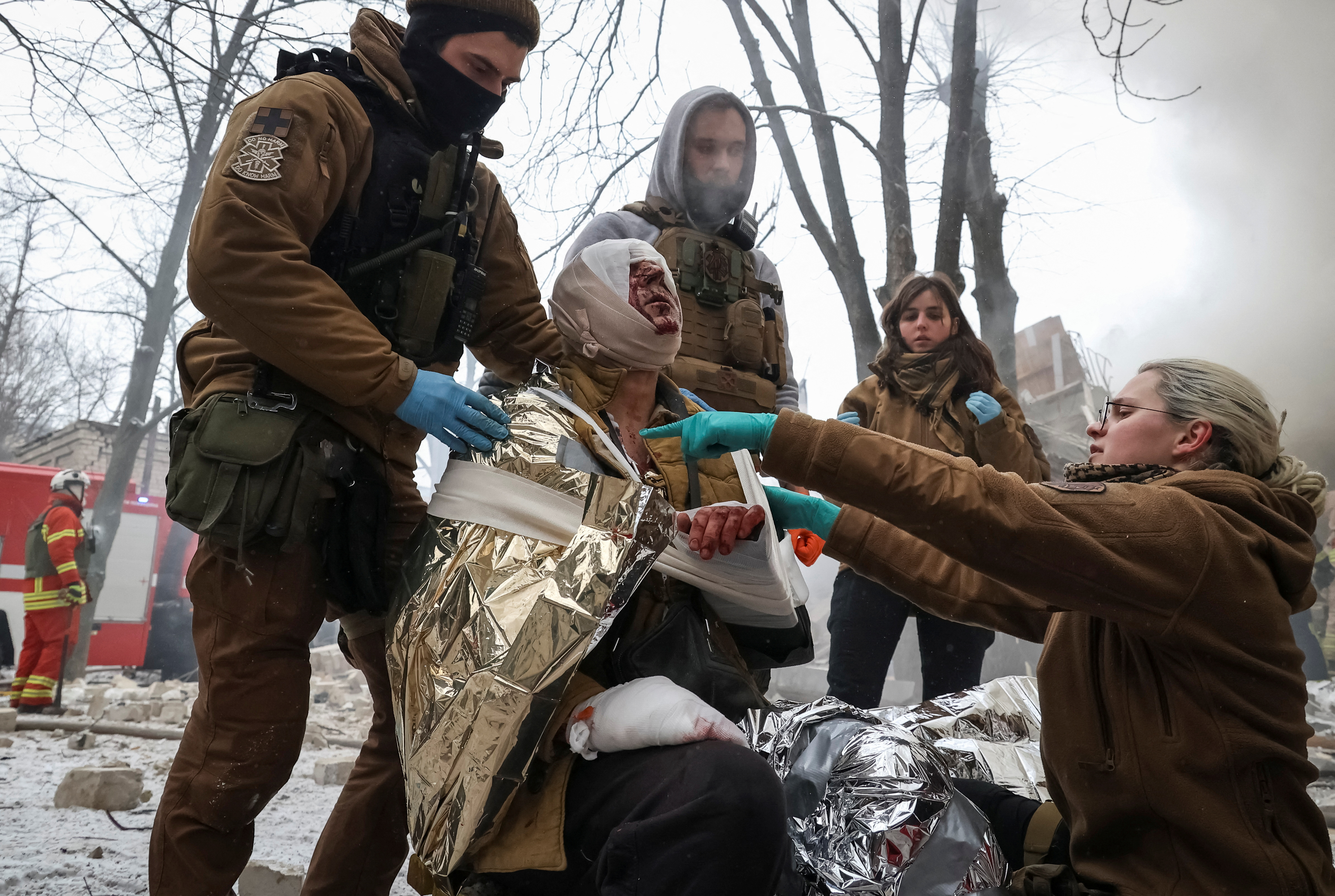 Medical workers treat a wounded local resident at a site of residential buildings heavily damaged during a Russian missile attack