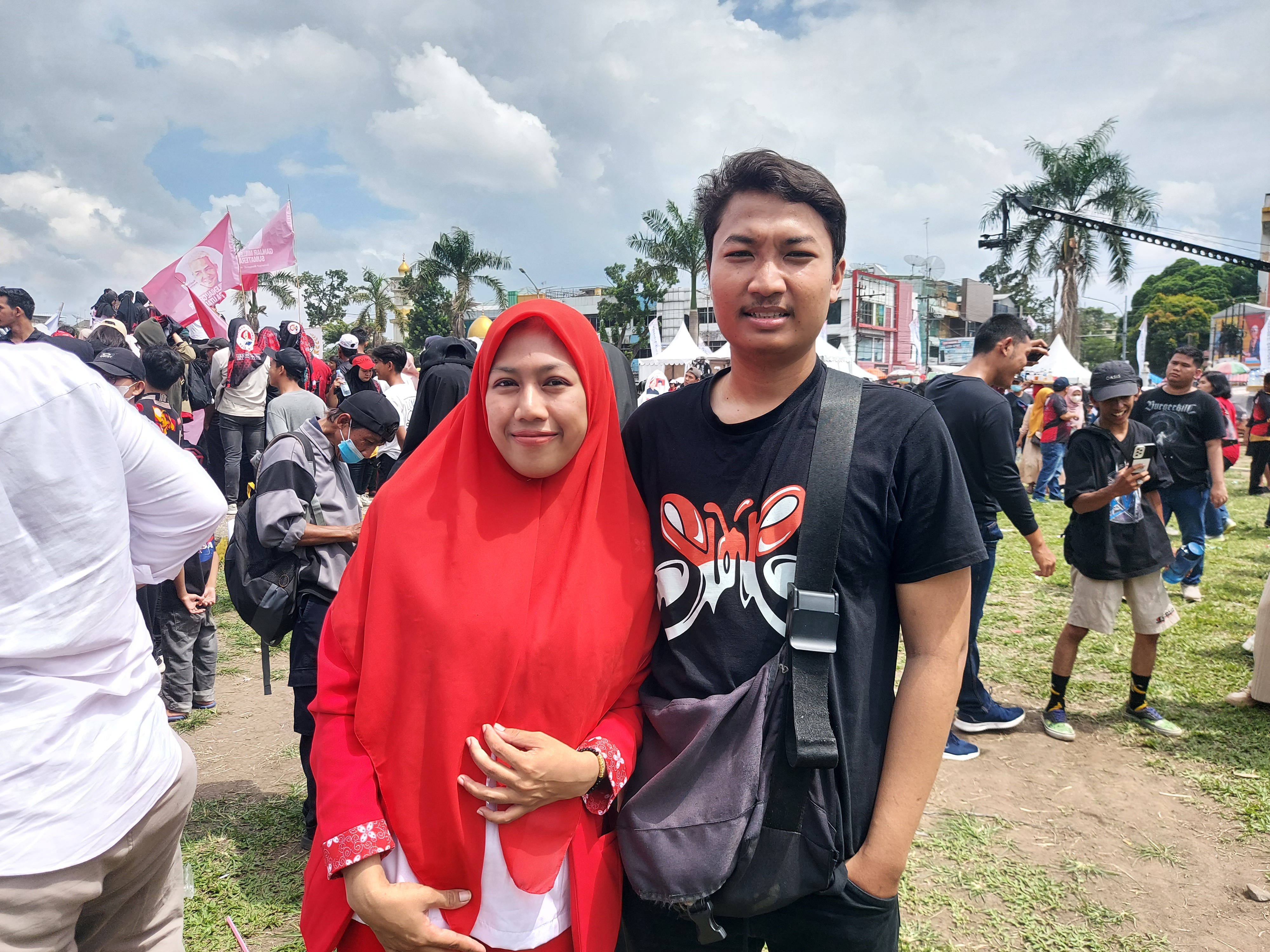 Husband and wife Cindy and Tio at the Slank concert. He is wearing a black Slank T-shirt. She is dressed in red and white.