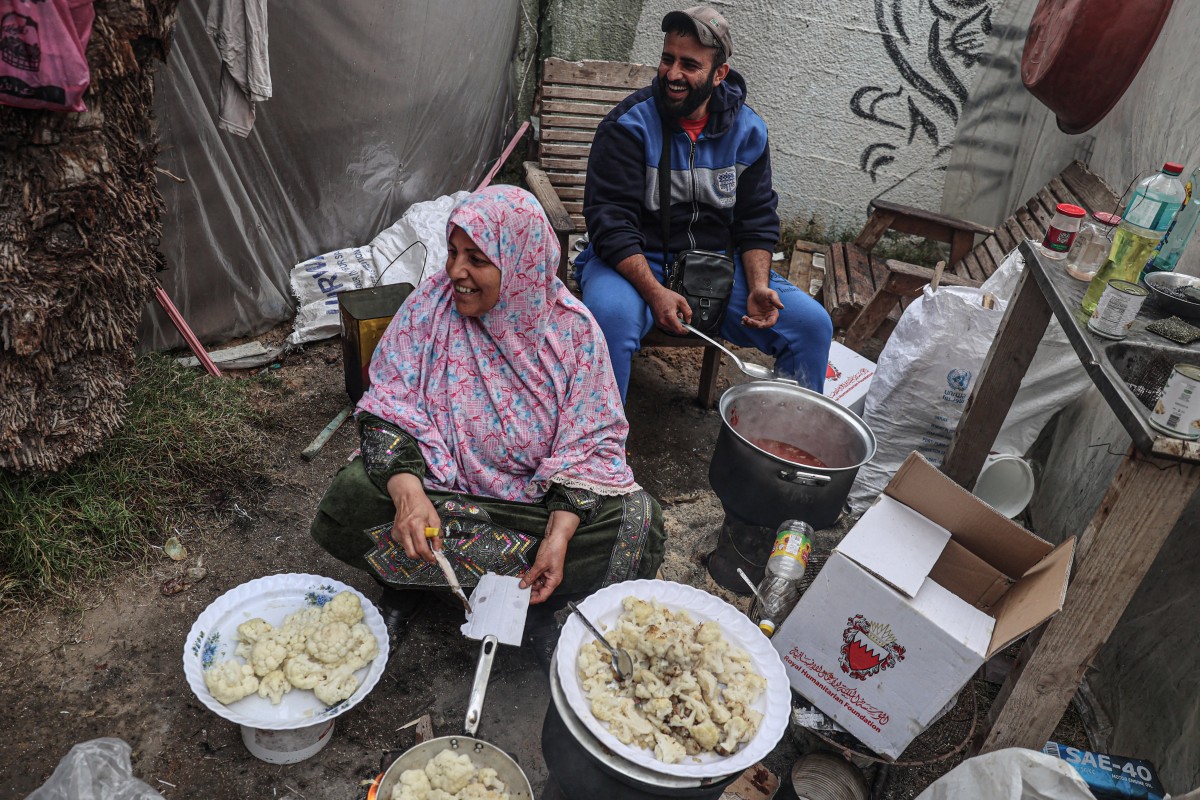 Displaced Palestinians cook a meal inside their shelter at the zoo in Rafah in the southern Gaza Strip, on January 2, 2024.