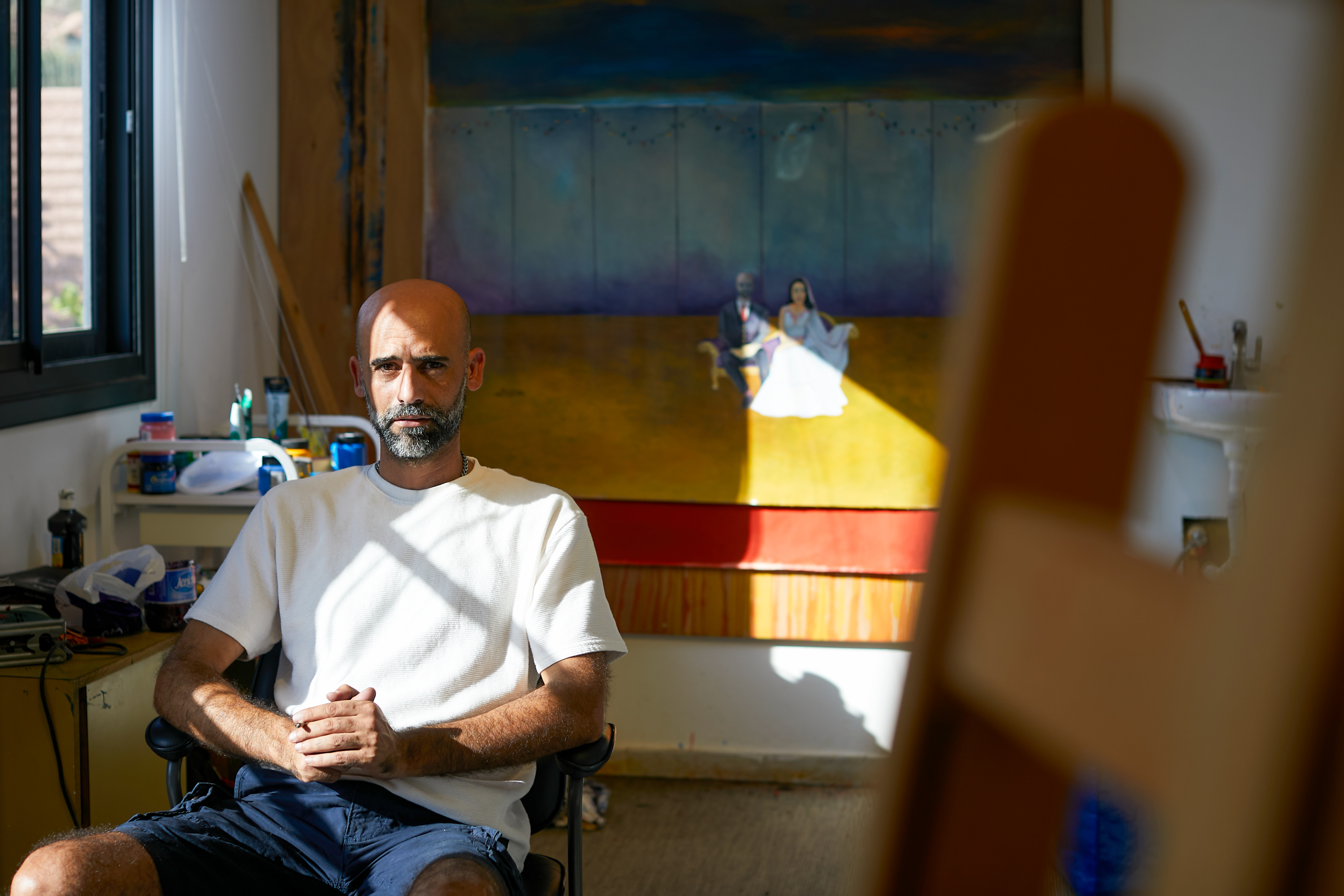 Ahed in white shirt and blue shorts in his studio