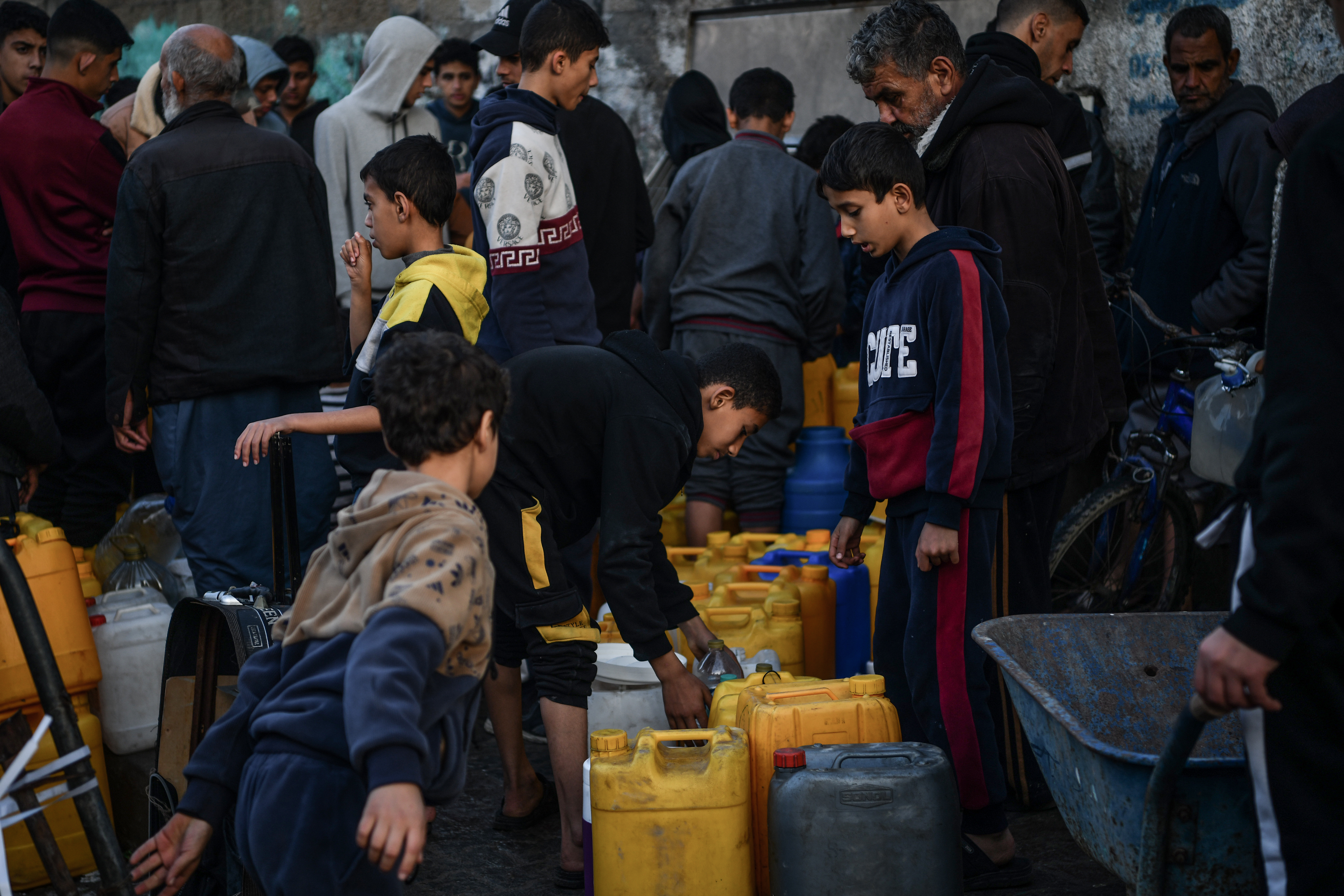 Palestinians wait in line to get clean water from the fountain while Israel's attacks continue on Gaza Strip as Palestinians who took refuge in the city of Rafah are trying to continue their daily work even though the attacks continue in Rafah, Gaza on January 03, 2024