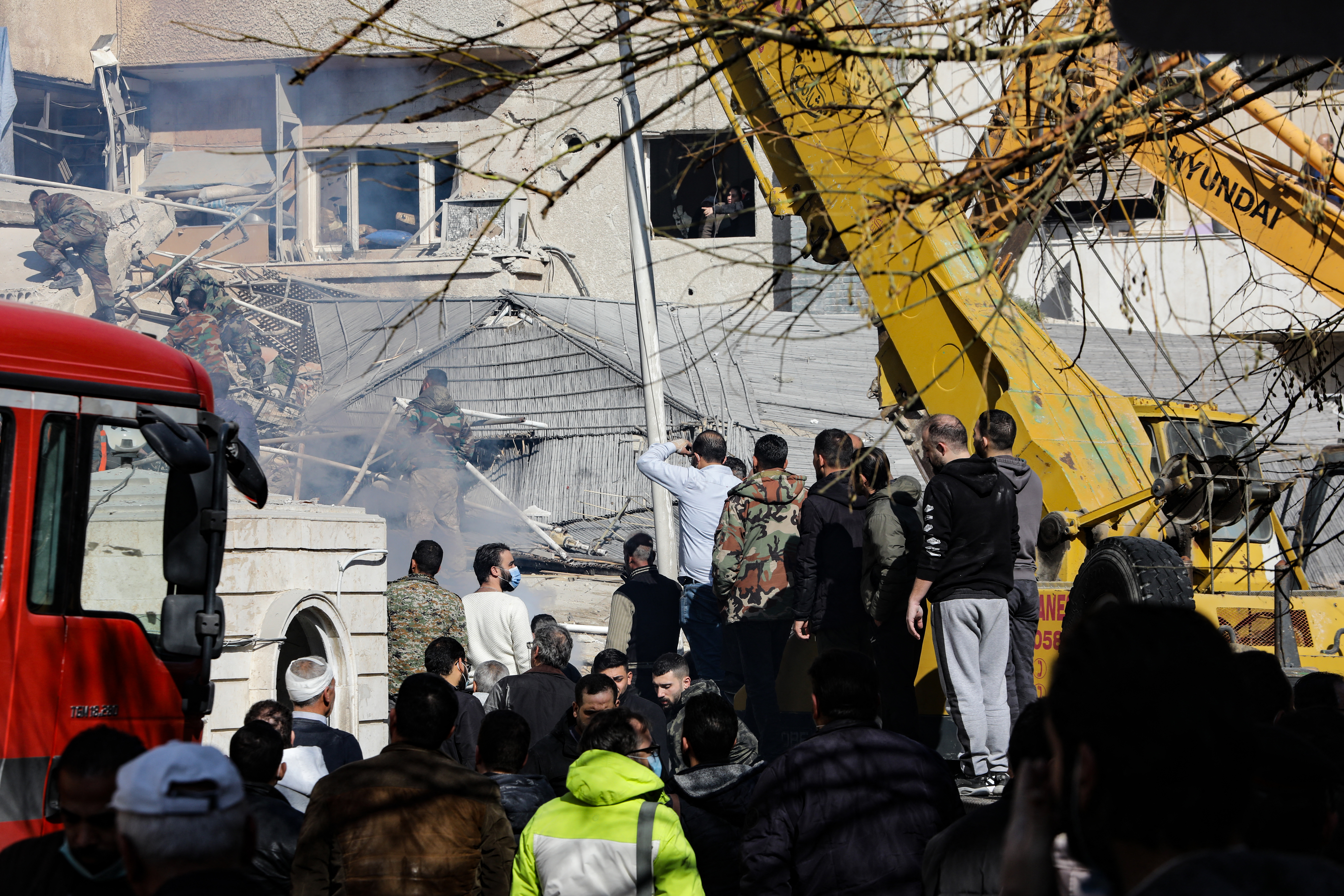 People and security forces gather in front of a building destroyed in a reported Israeli strike in Damascus on January 20