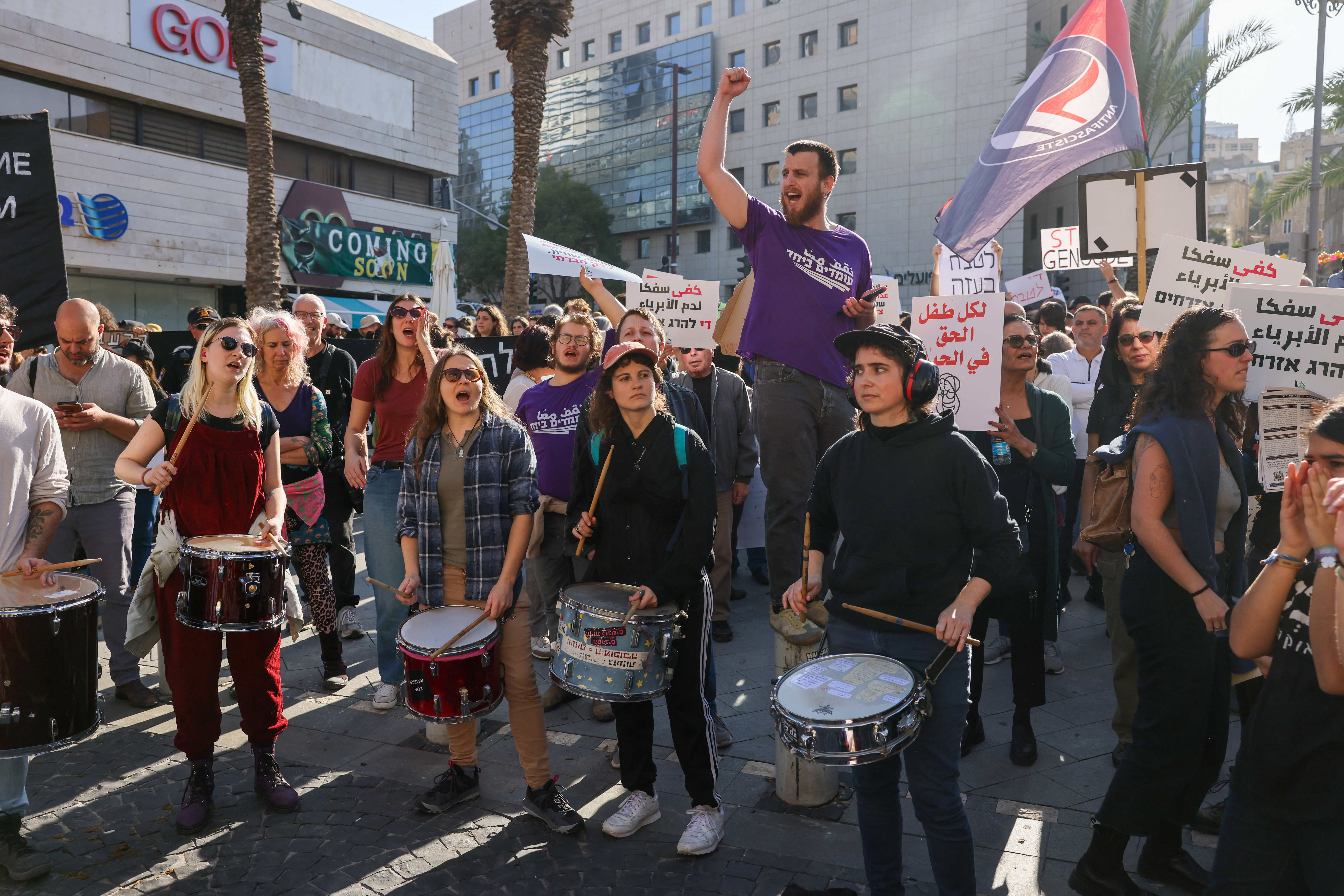 People hold placards as they take part in a protest calling for a ceasefire and for the release of Israeli hostages held in Gaza