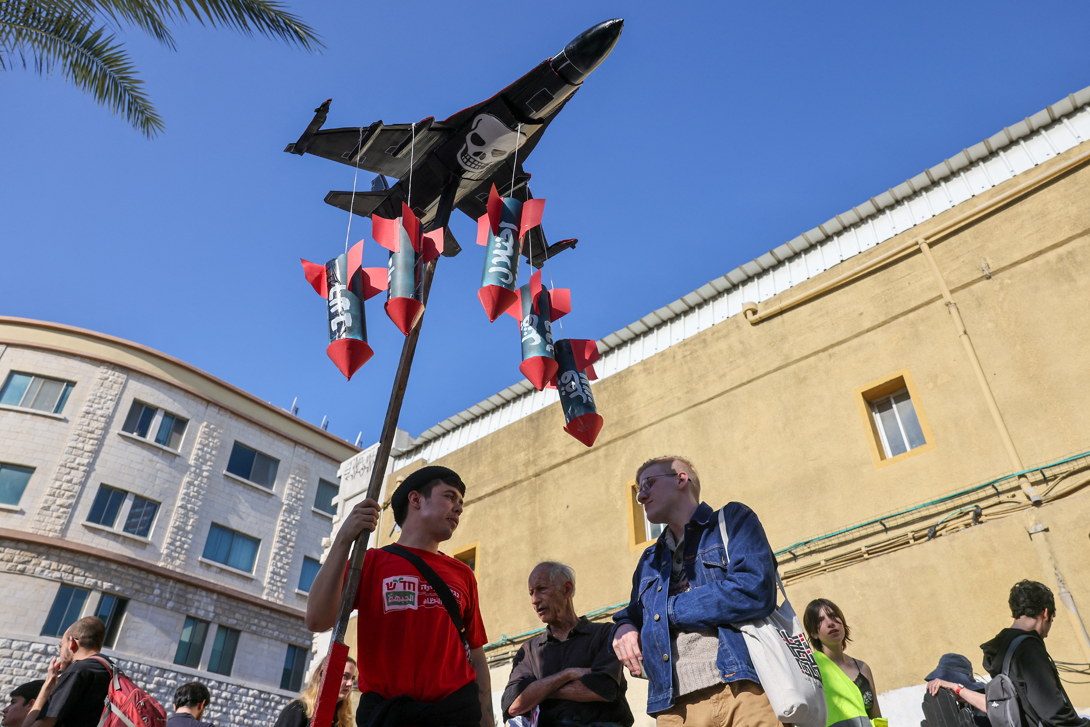 A man holds a mock fighter jet during a protest calling for a ceasefire and for the release of Israeli hostages held in Gaza