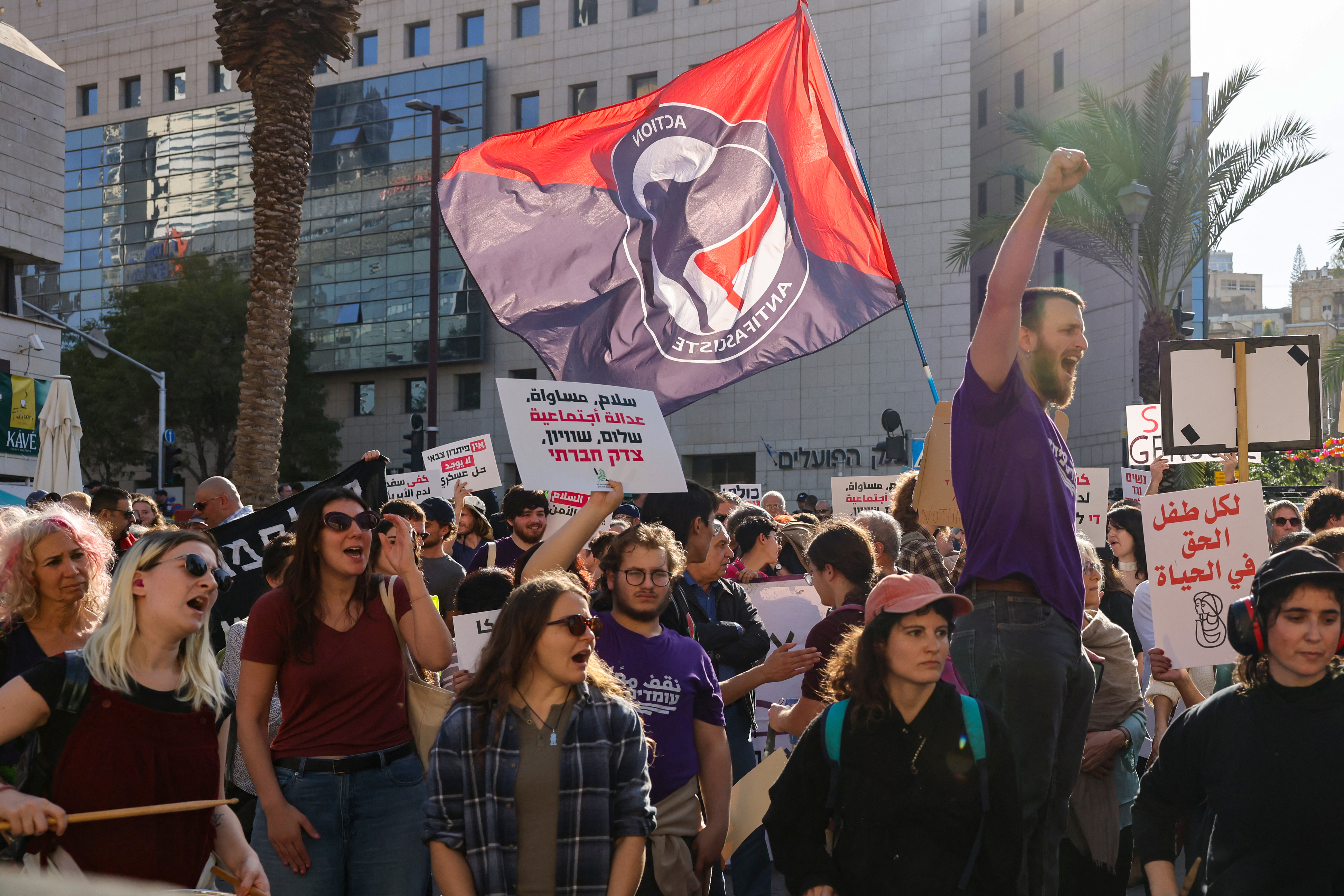 People hold placards and shout slogans as they take part in a protest calling for a ceasefire and for the release of Israeli hostages held in Gaza