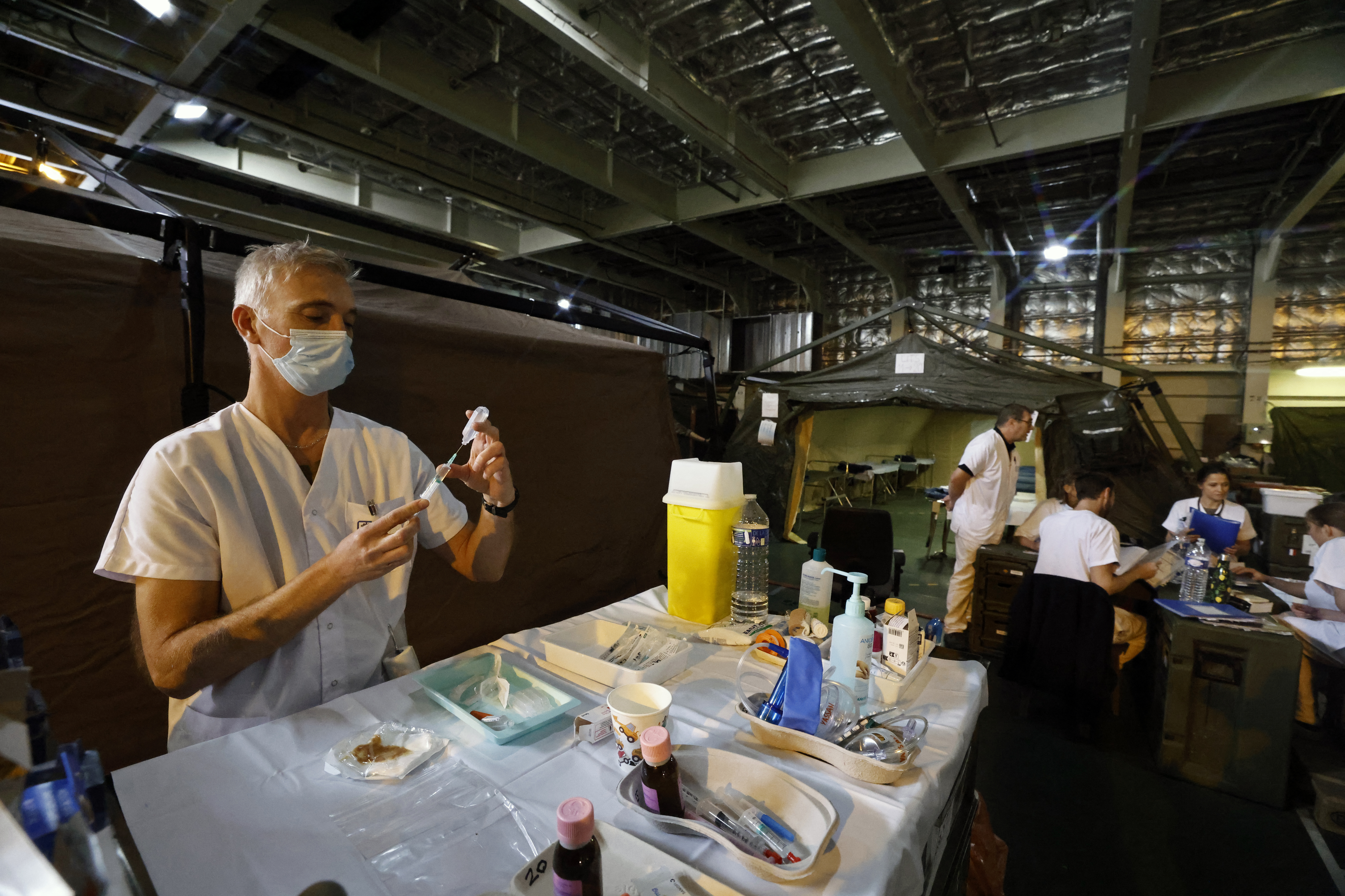 Military medical personnel work onboard the French LHD Dixmude military ship