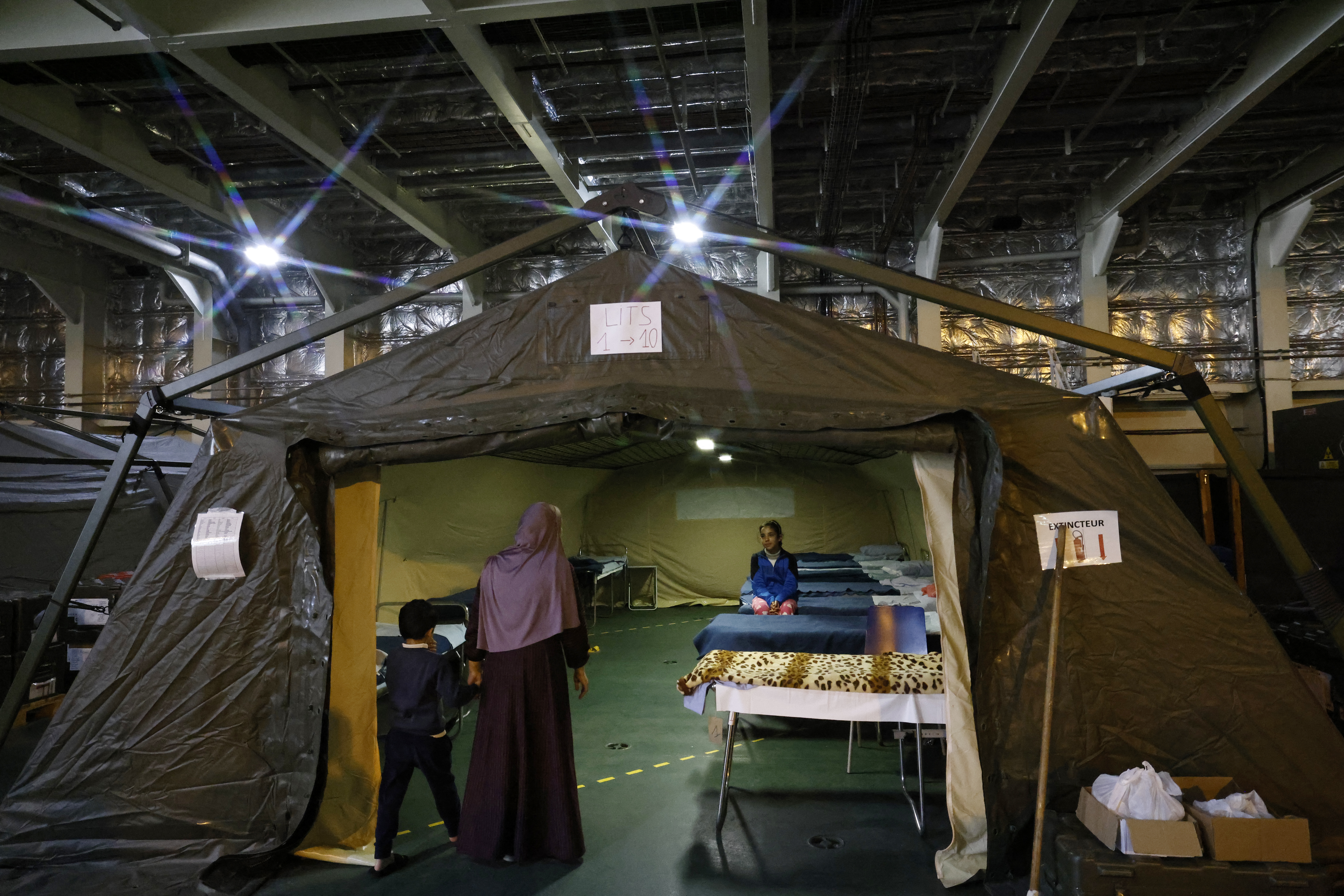 A Palestinian child sits on a bed under a tent onboard the French LHD Dixmude military ship, which serves as a hospital to treat wounded Palestinians, as it docks at the Egyptian port of Al-Arish on January 21
