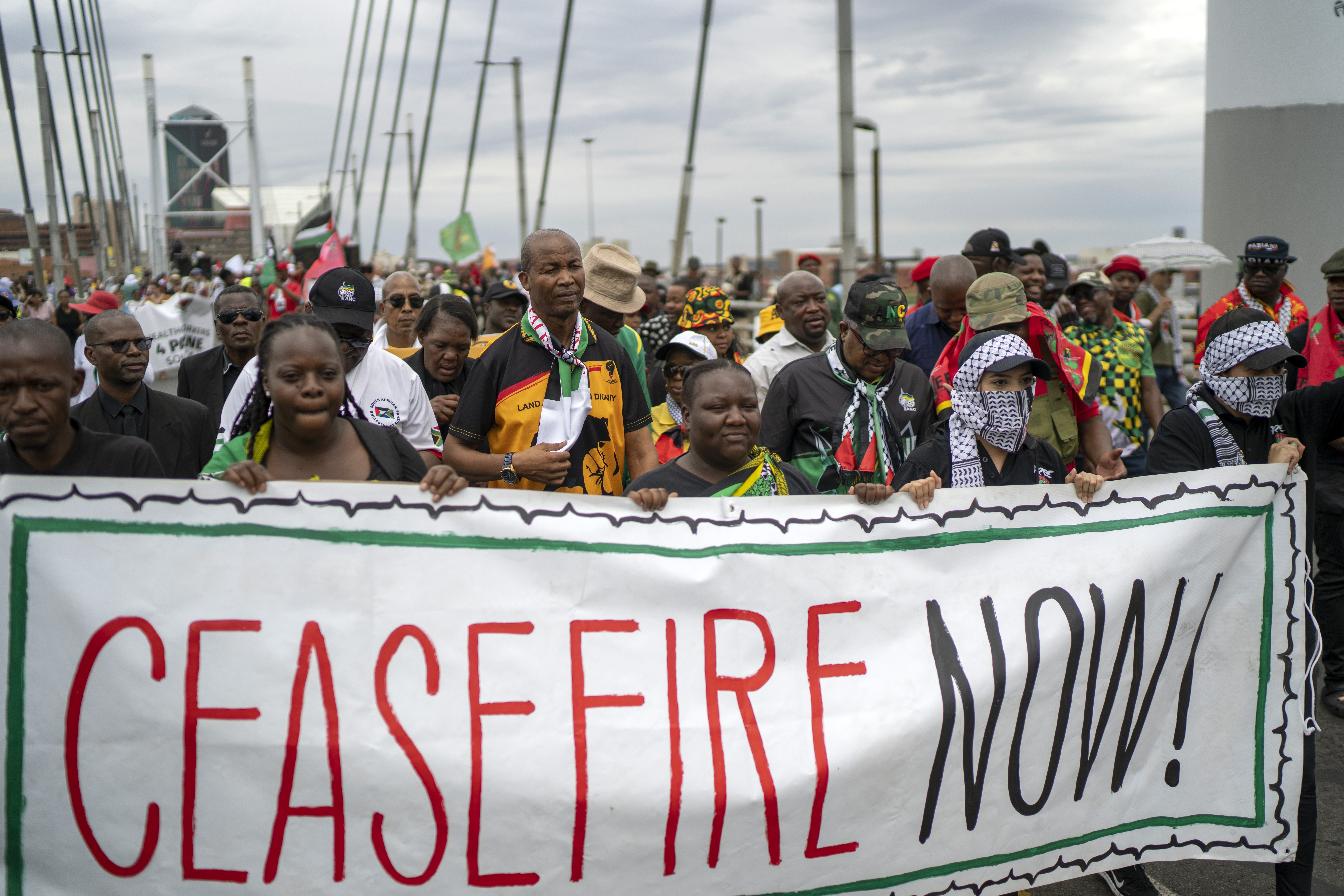 Pro-Palestinian demonstrators march across the Mandela Bridge downtown Johannesburg, South Africa, Wednesday, Nov. 29, 2023. Hundreds marched to protest Israel's intervention in Gaza, calling for a permanent ceasefire. (AP Photo/Jerome Delay)
