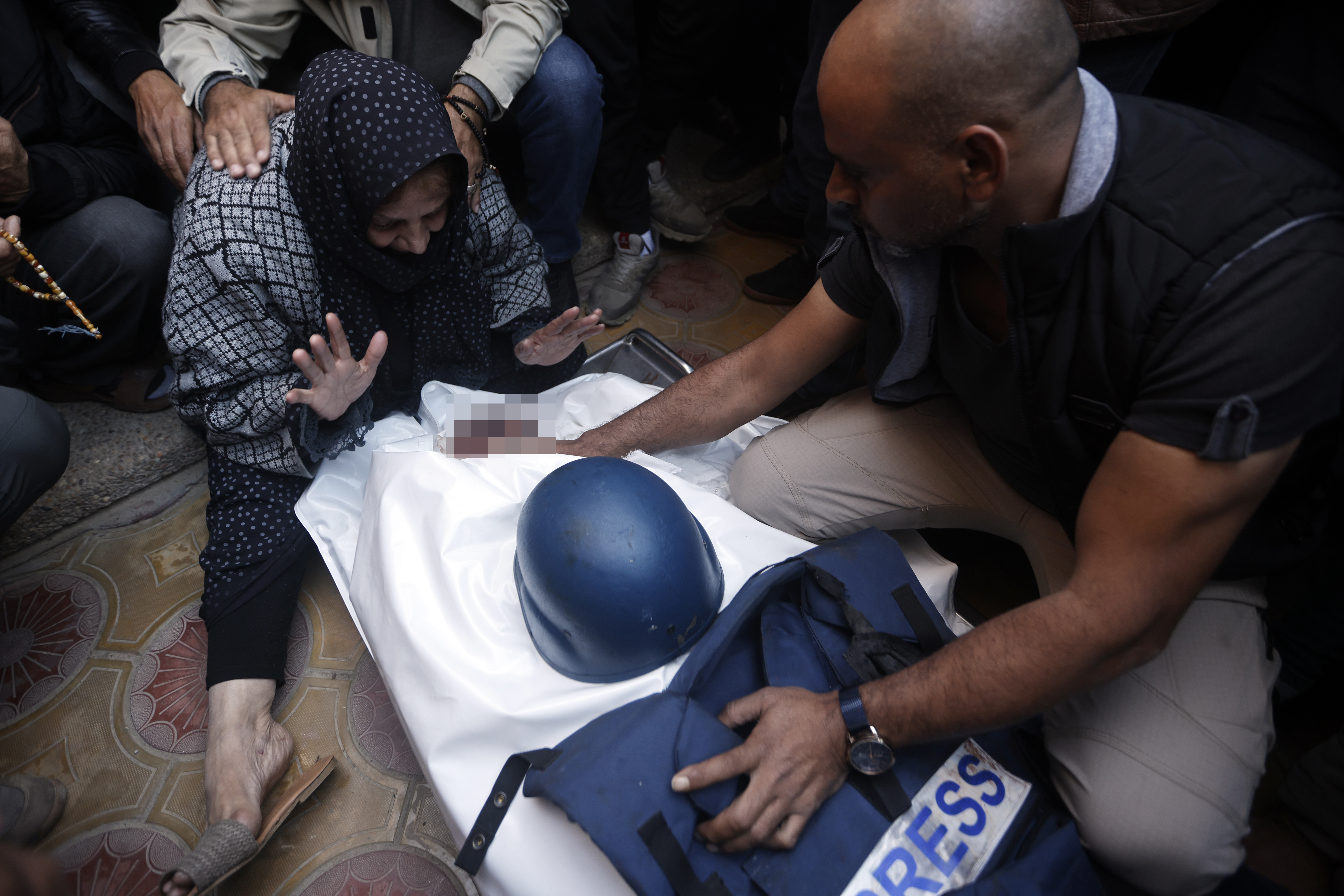 Relatives of Al Jazeera cameraman Samer Abu Daqqa, who was killed by an Israeli attack, mourn mourn over his body at his funeral in Khan Younis, Gaza on December 16, 2023 [Mohammed Dahman/AP Photo]