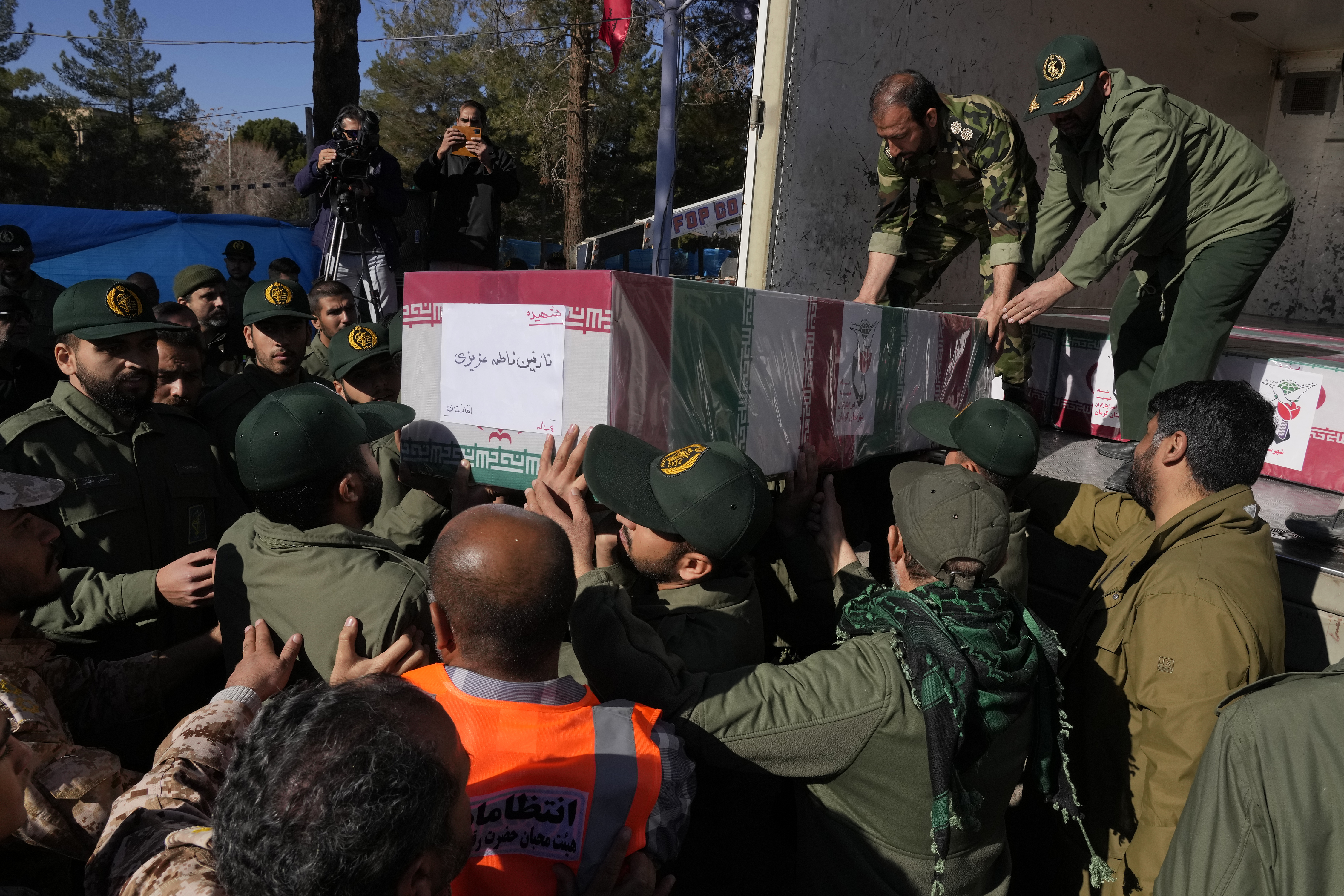 Revolutionary Guard members carry the Iranian flag-draped coffin of Nazanin Fatemeh Azizi