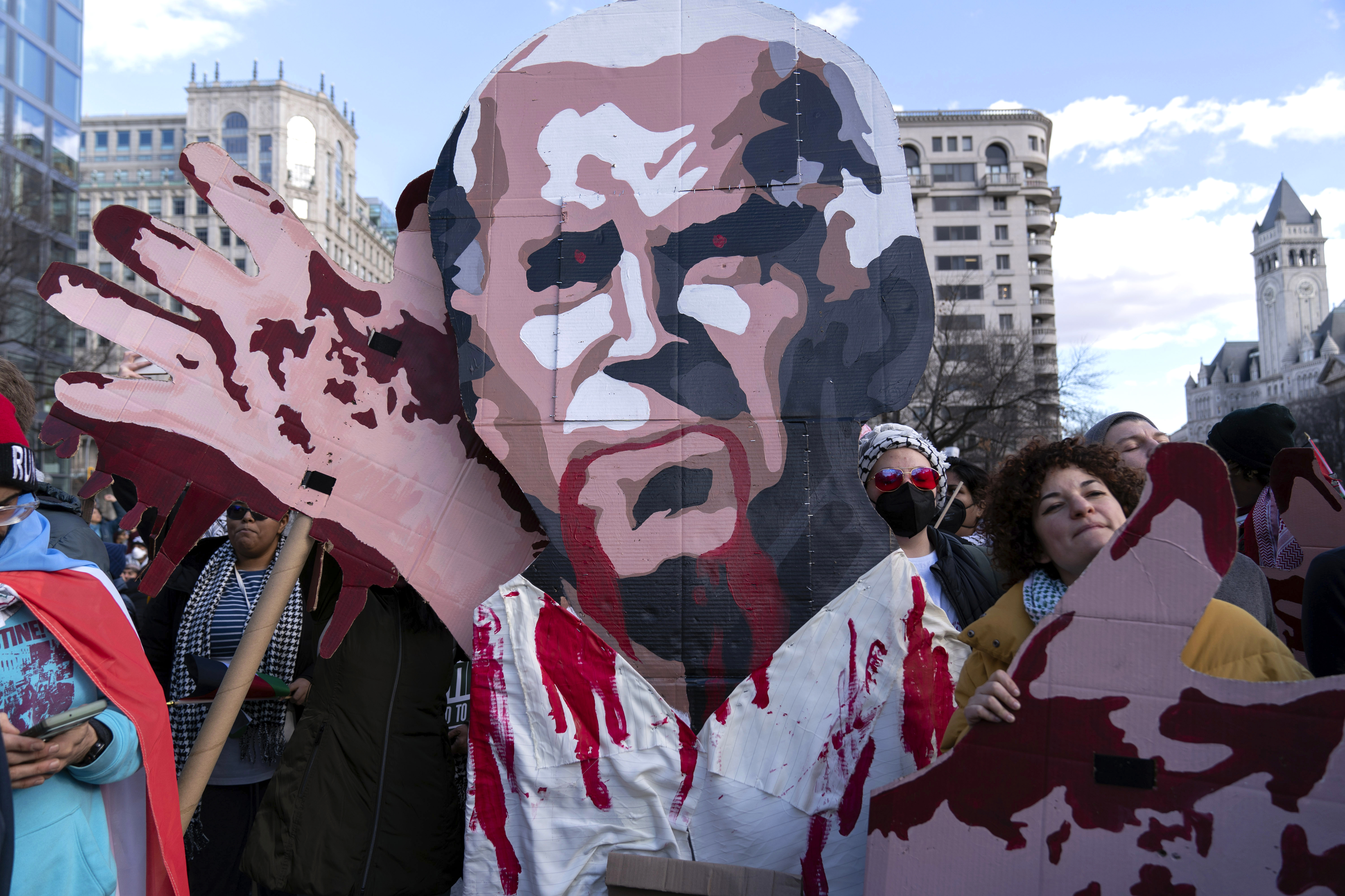Demonstrators rallying for Gaza in Washington, DC hold up a poster of Joe Biden's face