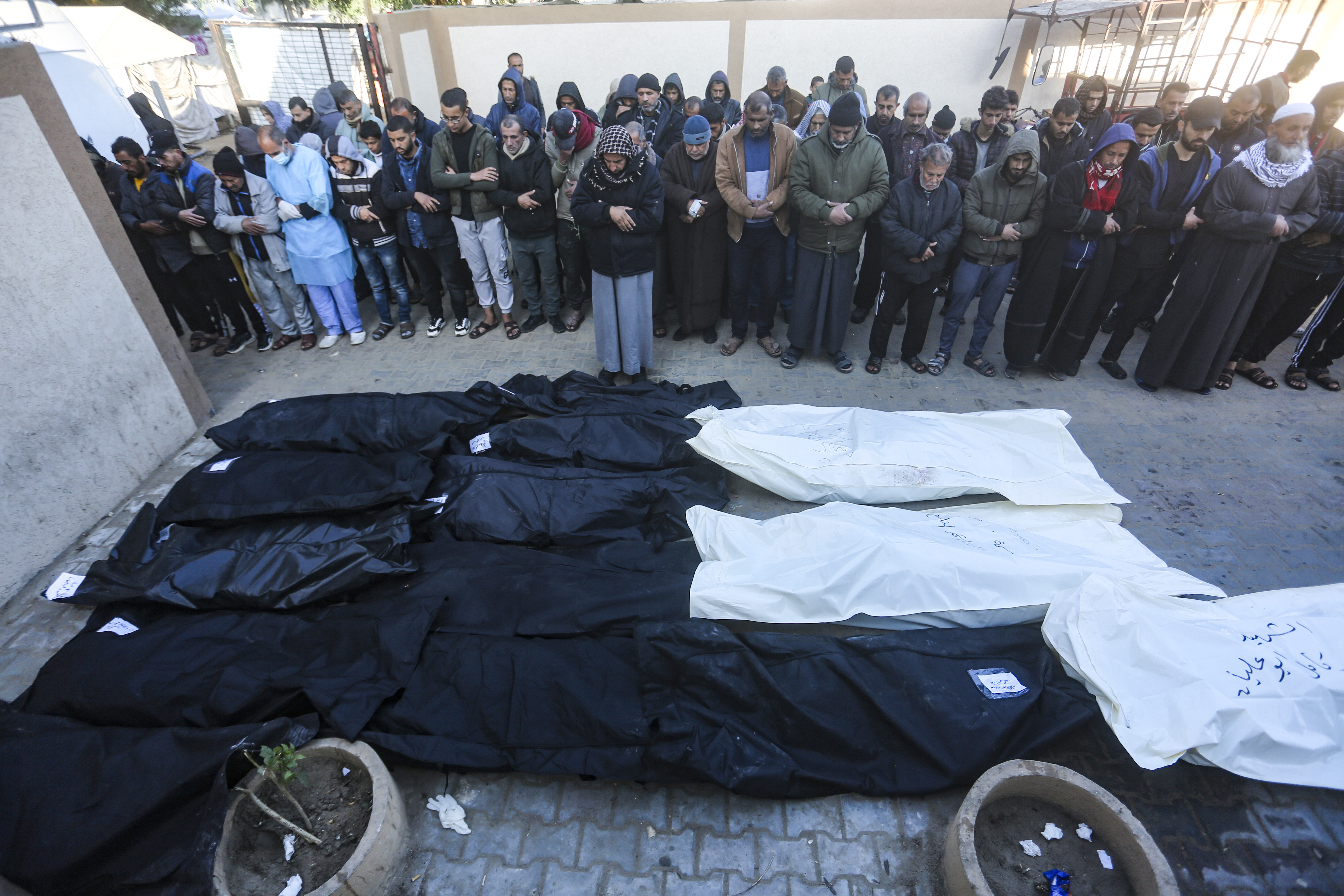 Palestinians pray for the relatives killed in the Israeli bombardment of the Gaza Strip in a morgue of the European Gaza Hospital in Khan Younis