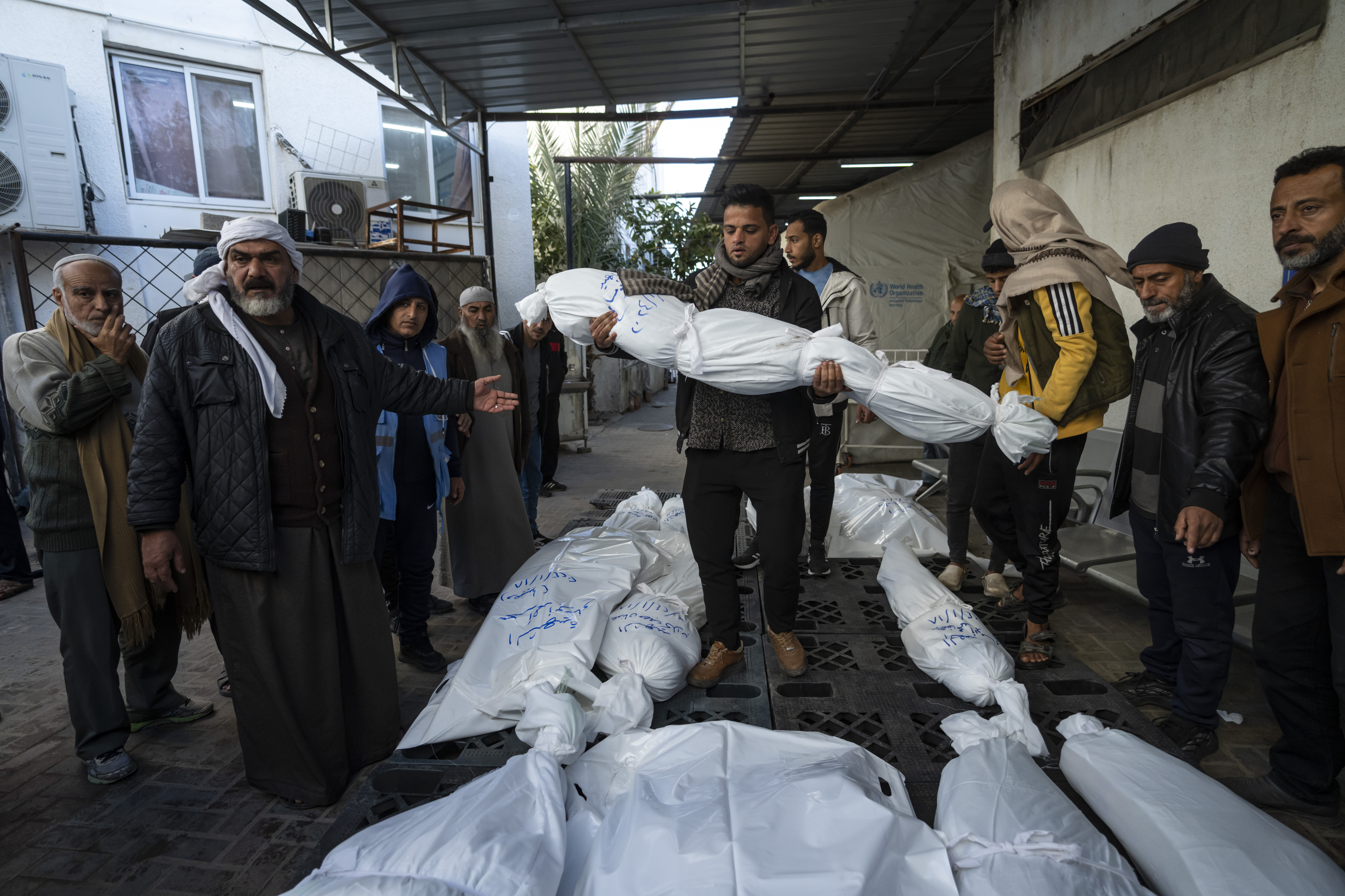 Palestinians mourn their relatives killed in the Israeli bombardment of the Gaza Strip, outside a morgue in Rafah