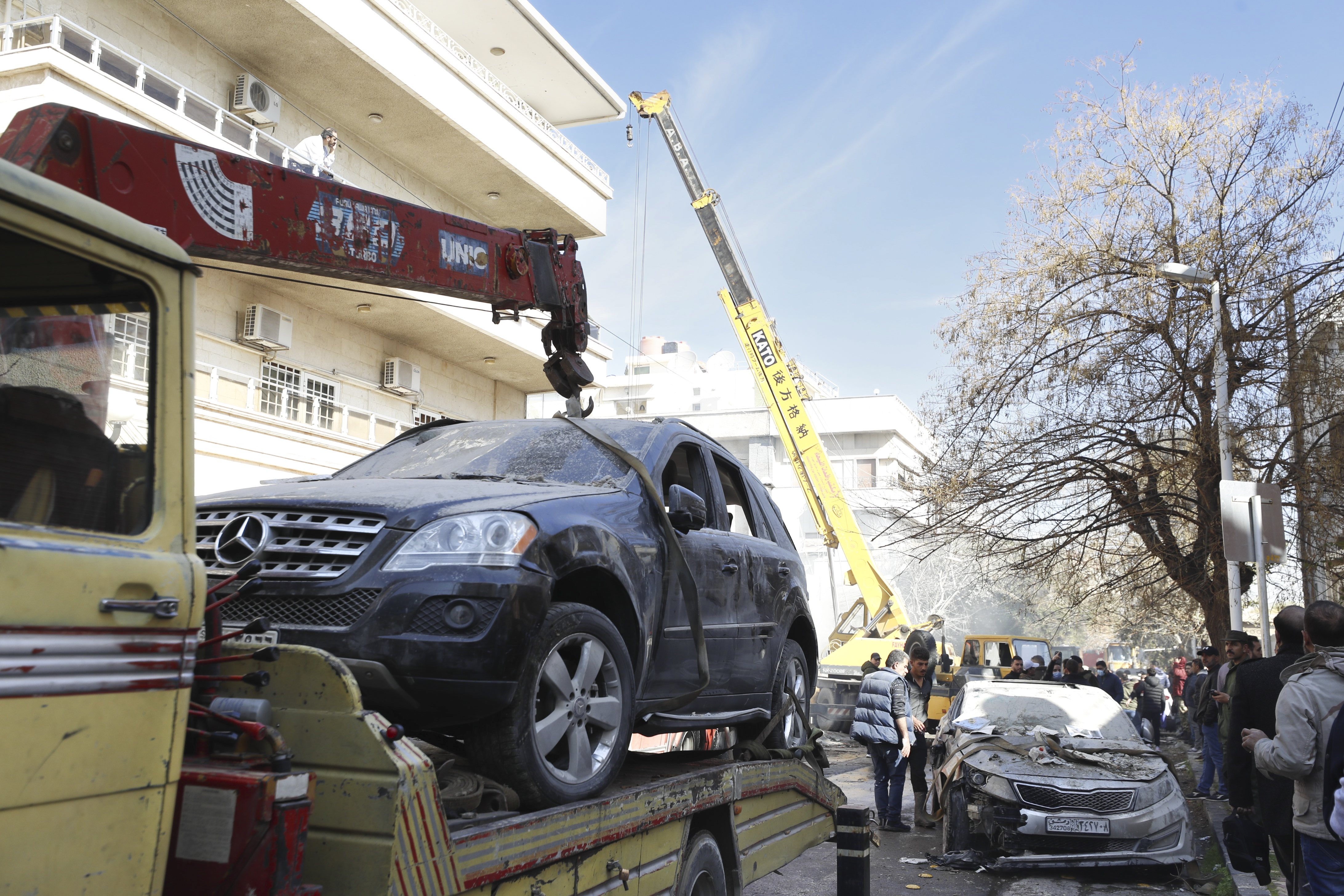 Emergency services work at a building hit by an air strike in Damascus, Syria, Saturday, Jan. 20