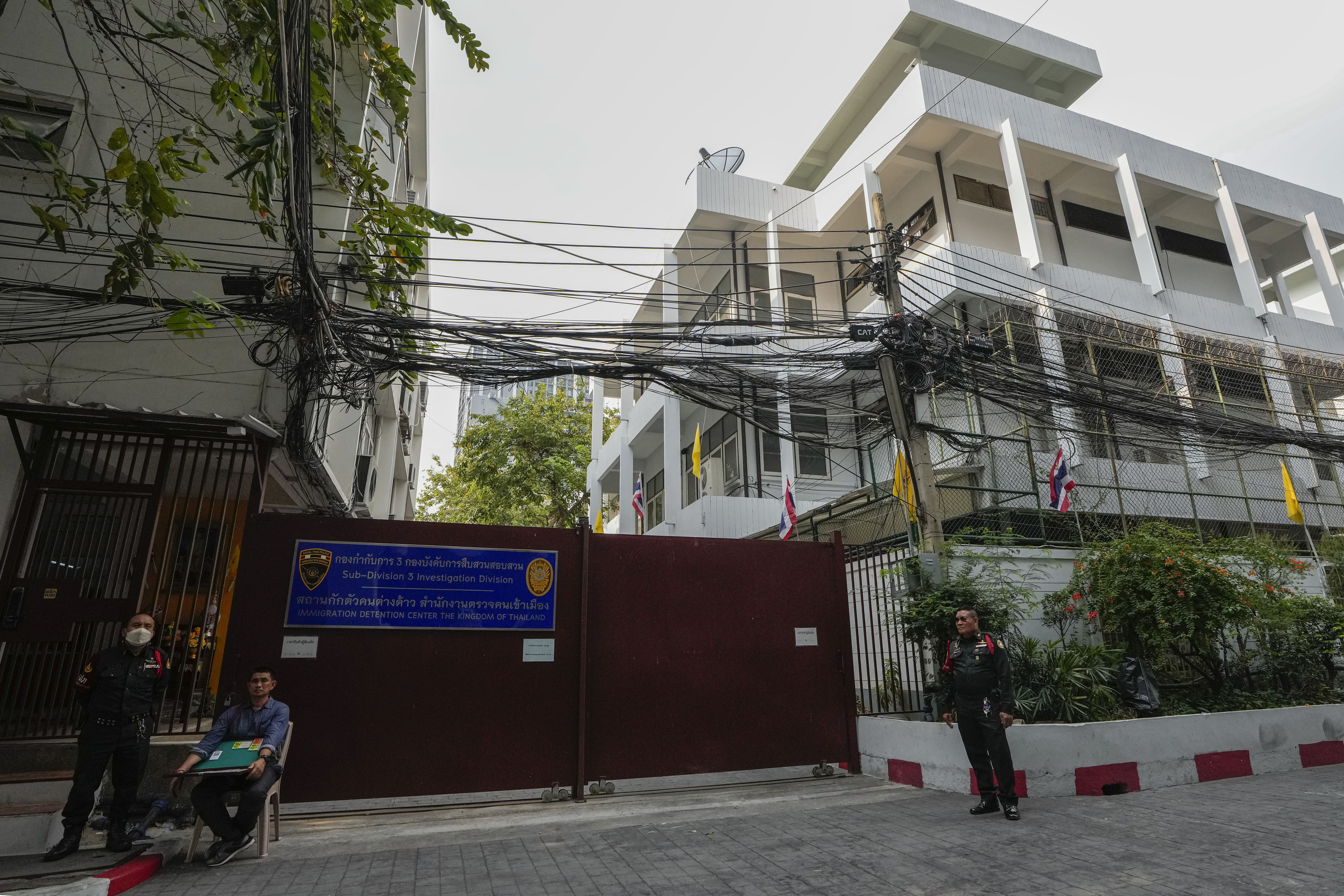 Security members stand guard outside the Immigration Detention Center in Bangkok, Thailand, 