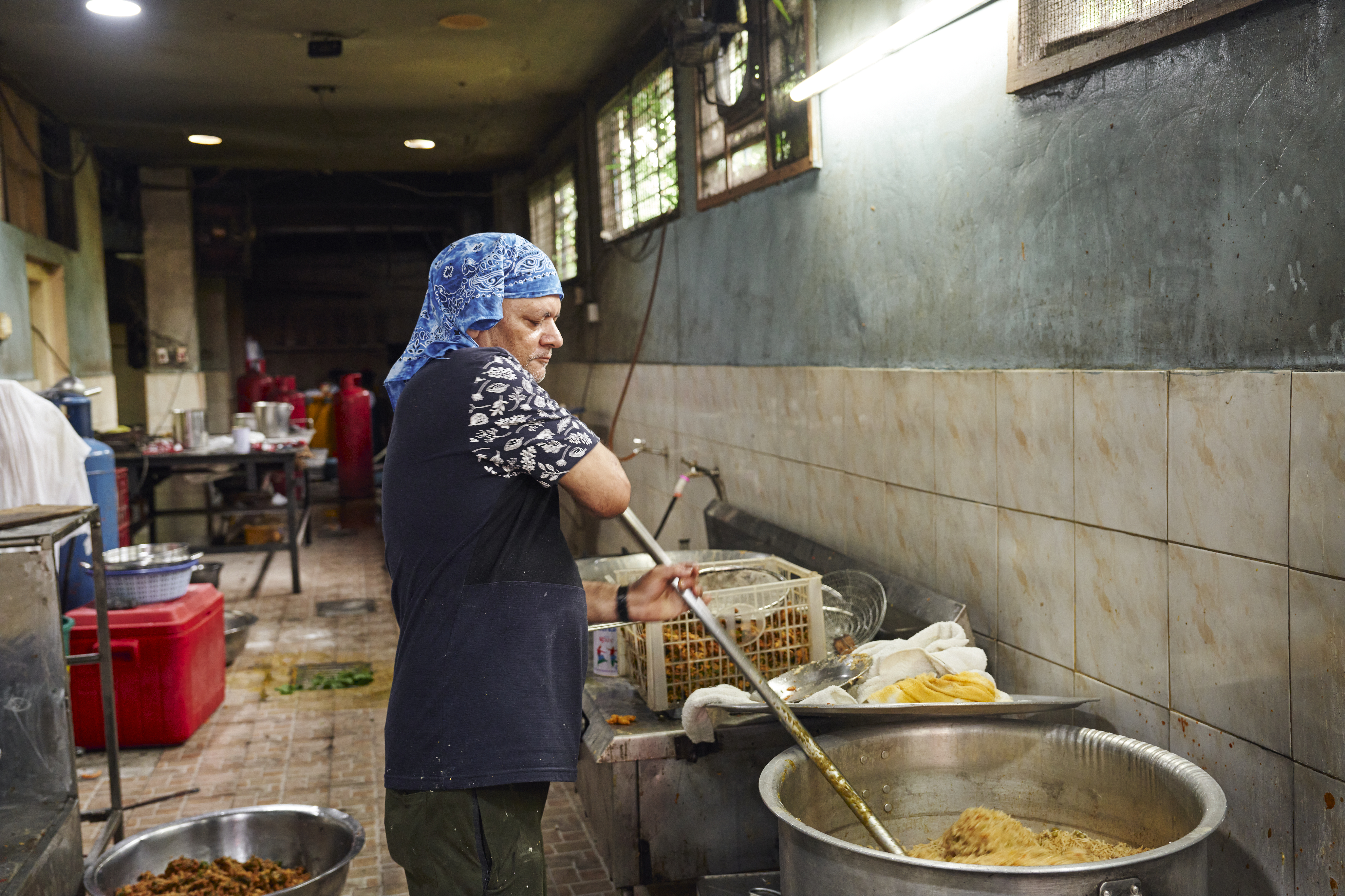 Bikram, who runs the kitchen at the Khalsa Diwan Sikh Temple in Manila, watches over the last batch of food from the morning’s cook. [Sonny Thakur/Al Jazeera]
