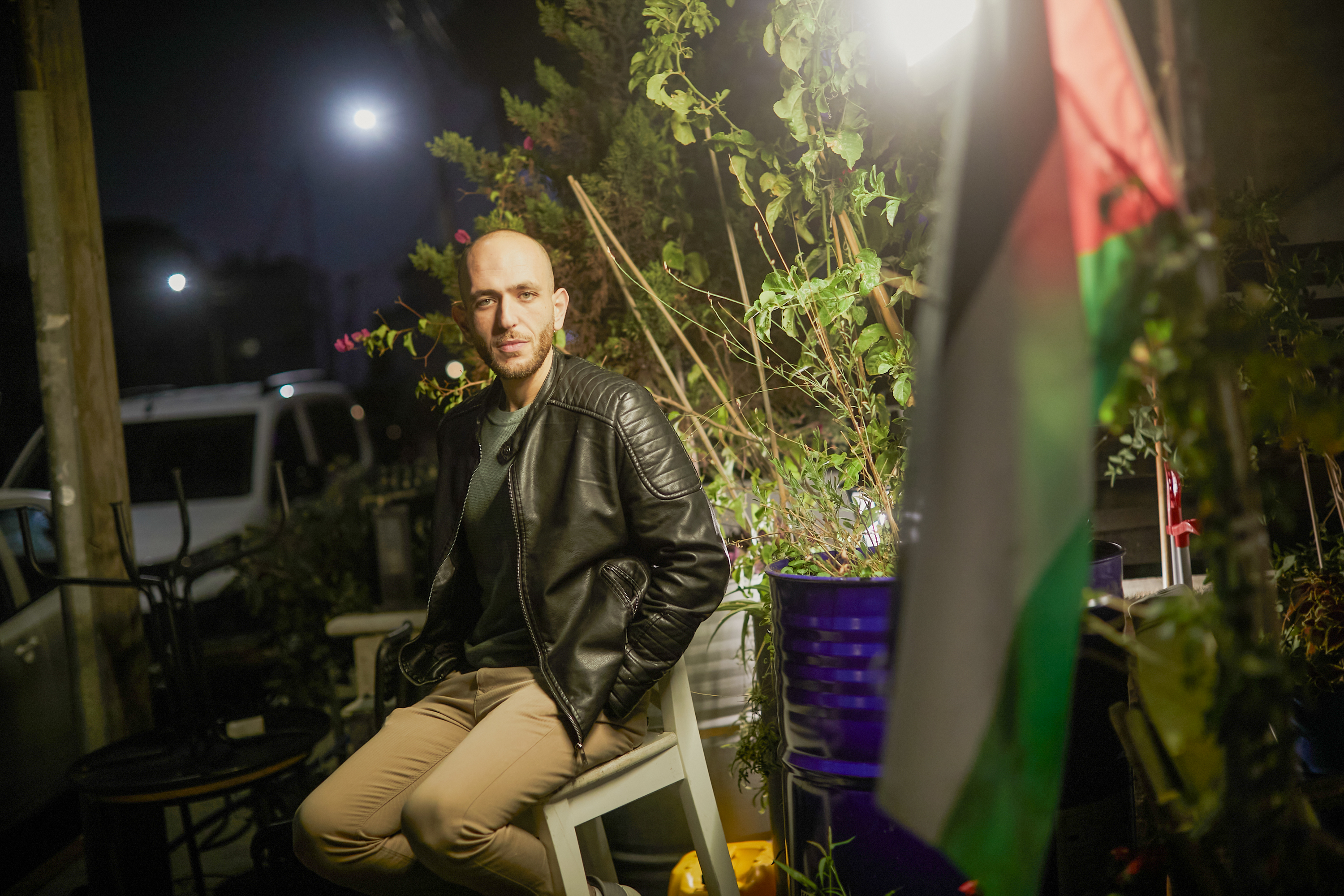 Ameed on a plastic chair in a garden at night