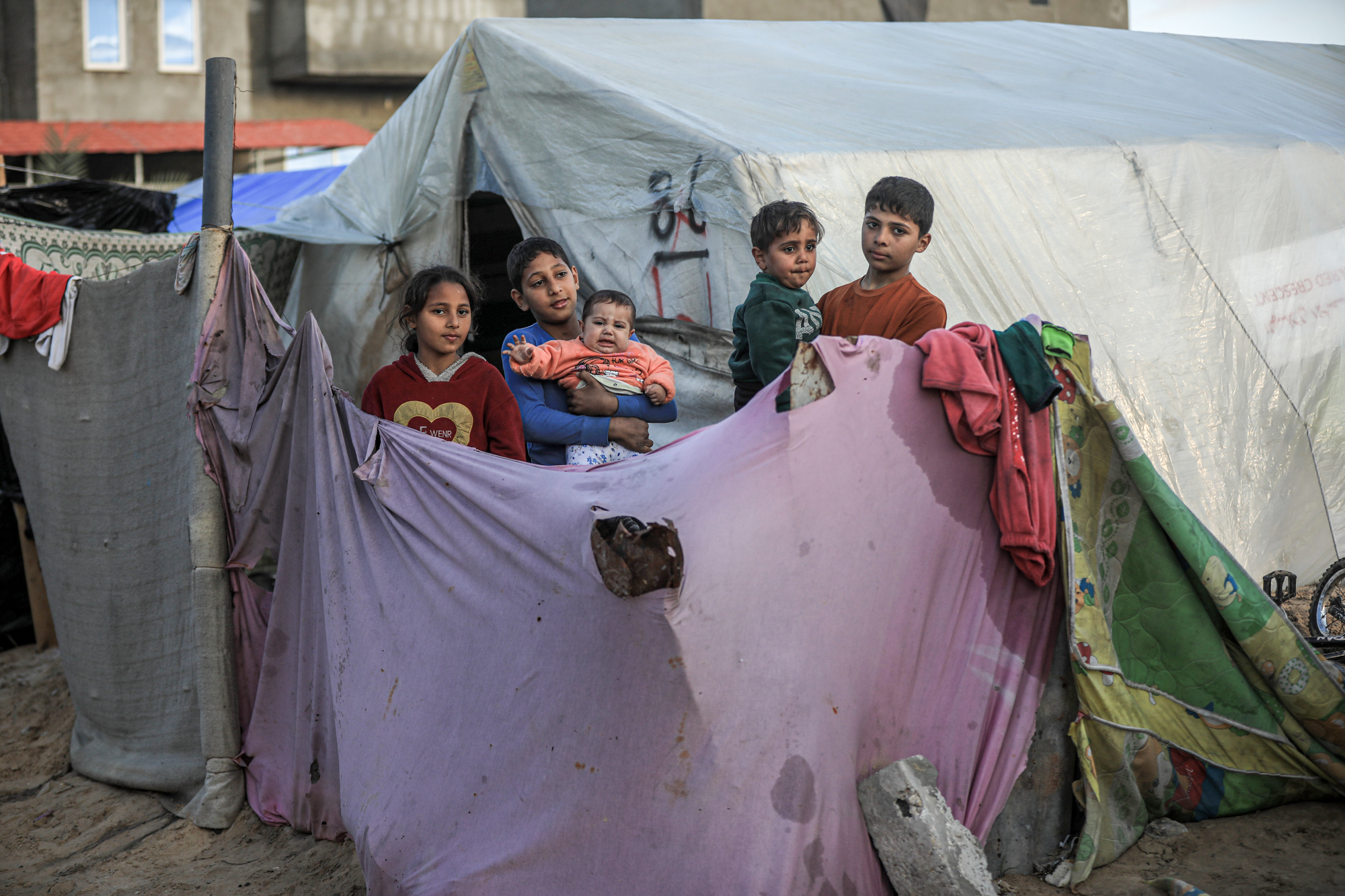 Five kids standing outside their tent