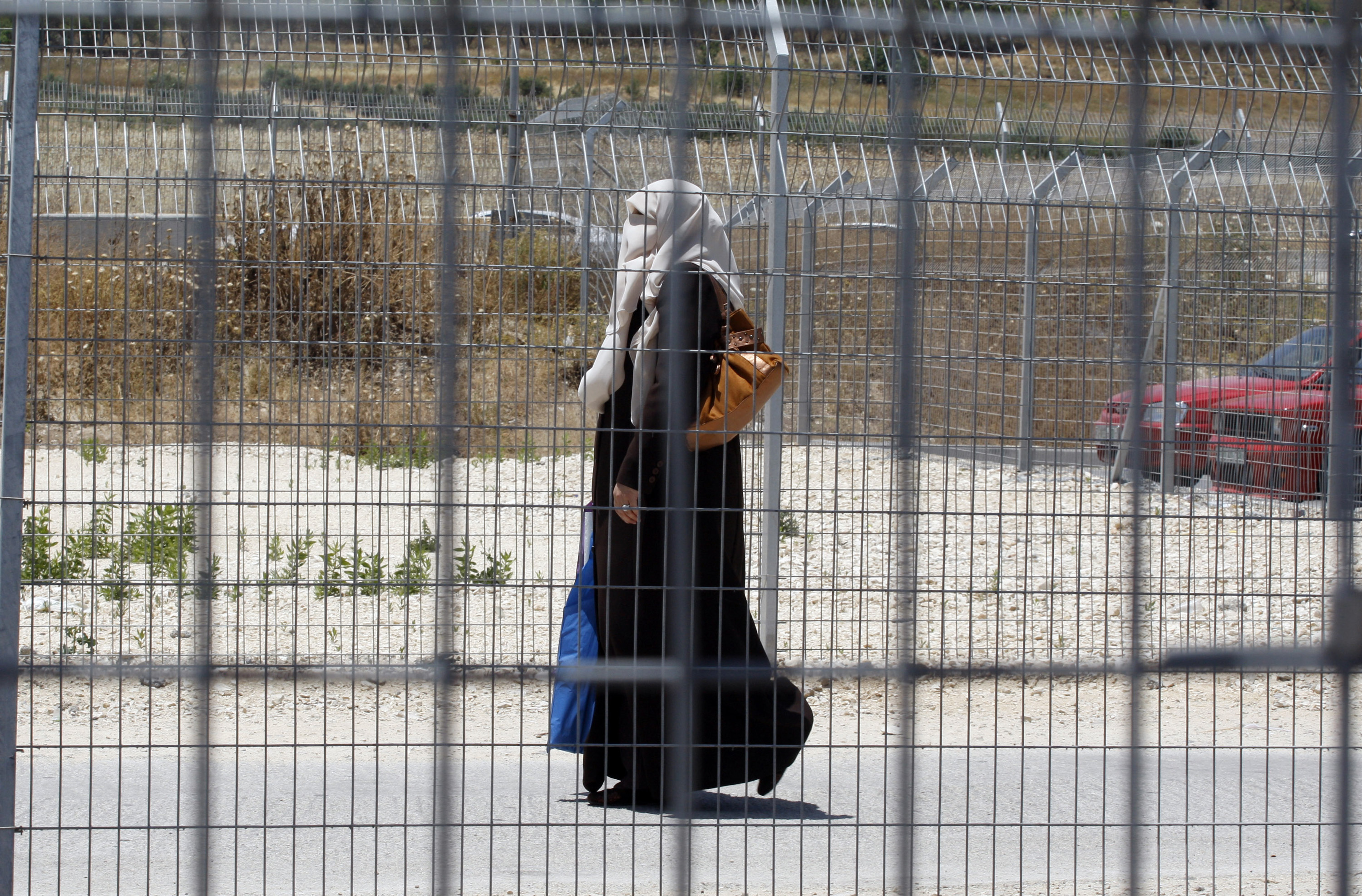A Palestinian woman passes through the Hawara checkpoint near the West Bank city of Nablus June 3, 2009.