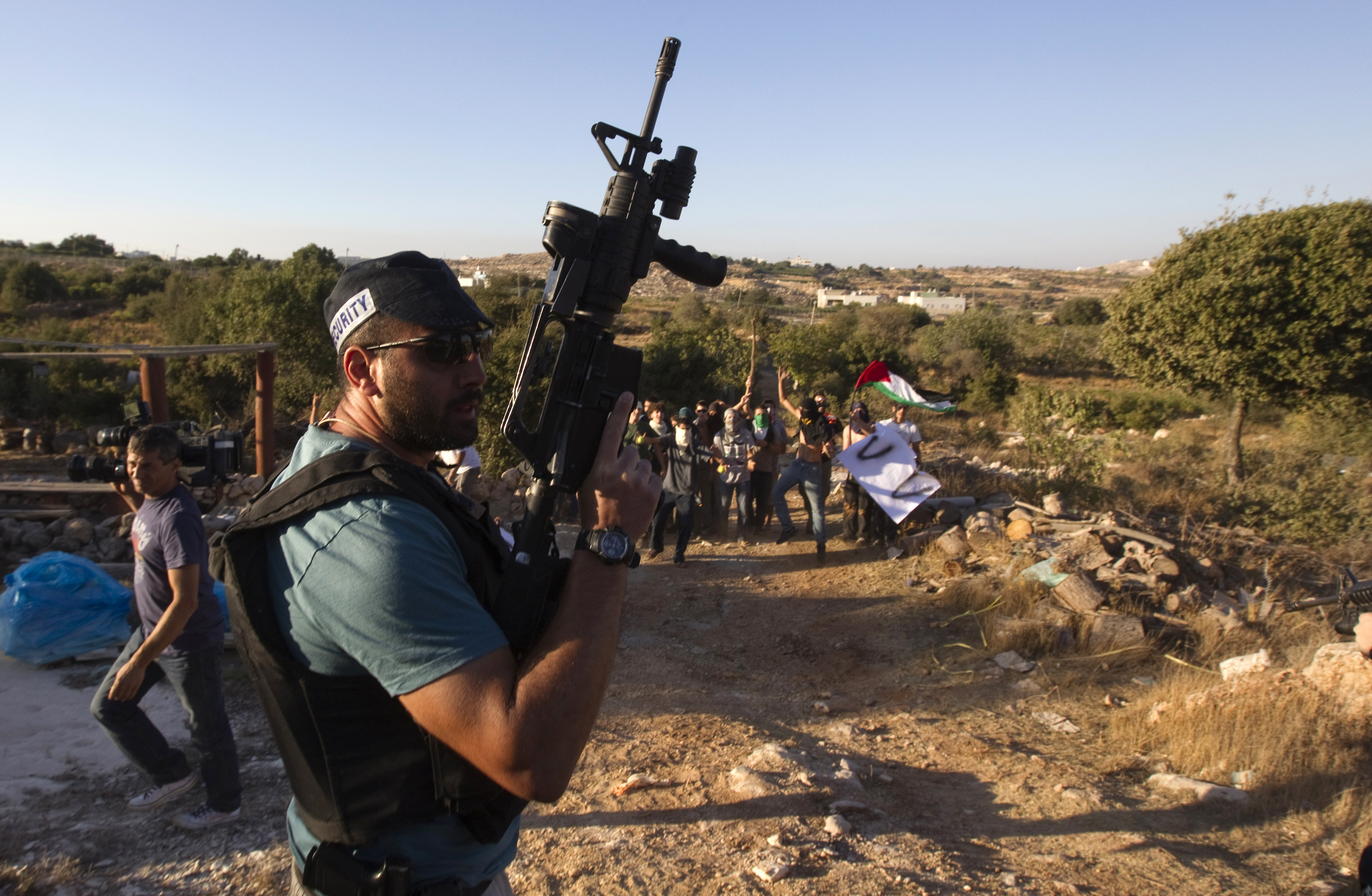 A Jewish settler stands guard as settlers dressed as Palestinian protesters participate in a drill, held by the settler's security response teams, simulating violence that could erupt ahead of the upcoming Palestinian bid for statehood at the United Nations September 14, 2011, in the West Bank settlement of Kiryat Arba. REUTERS/Ronen Zvulun (WEST BANK - Tags: POLITICS CIVIL UNREST)