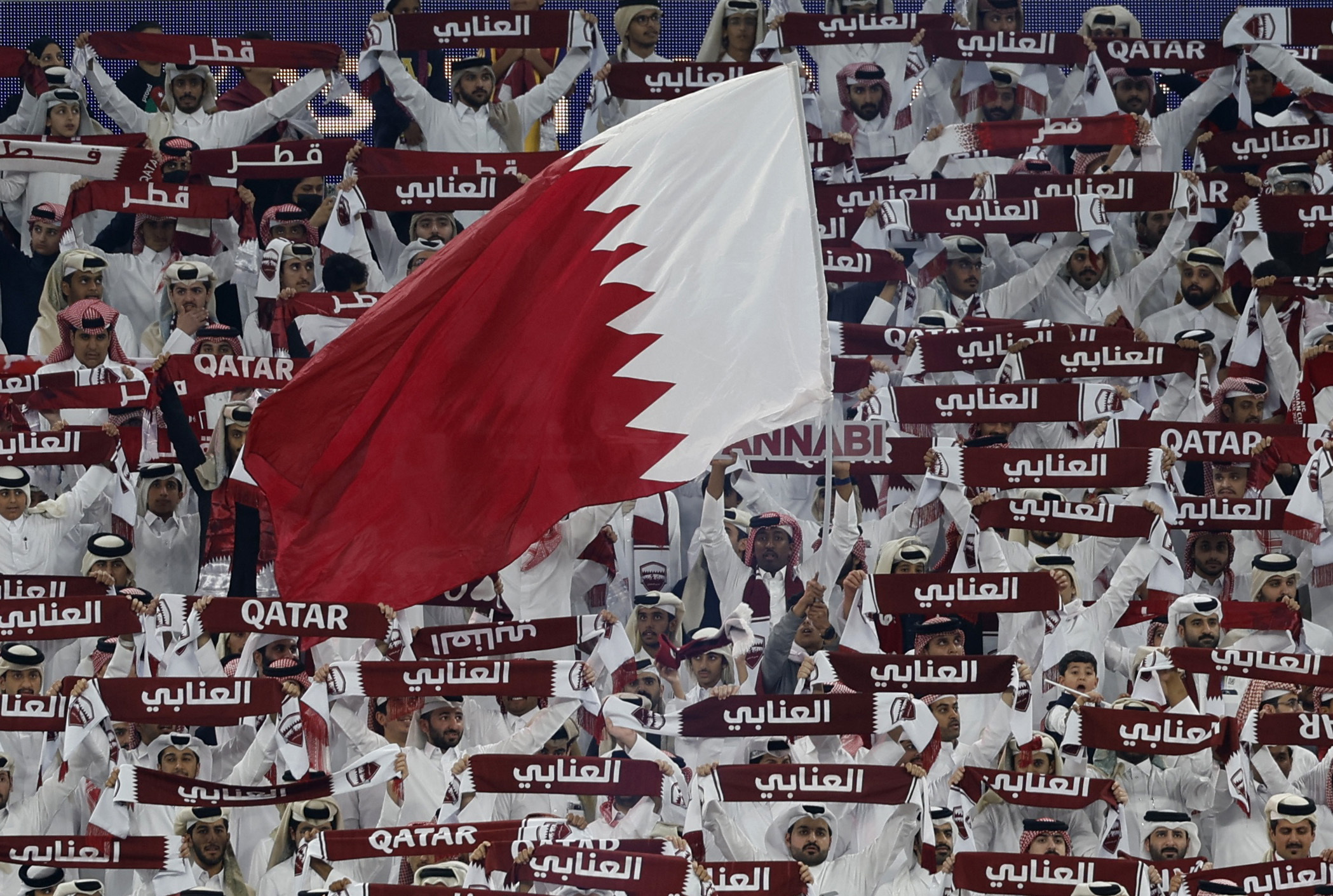 Qatar fans holding a large flag inside the stadium before the match.