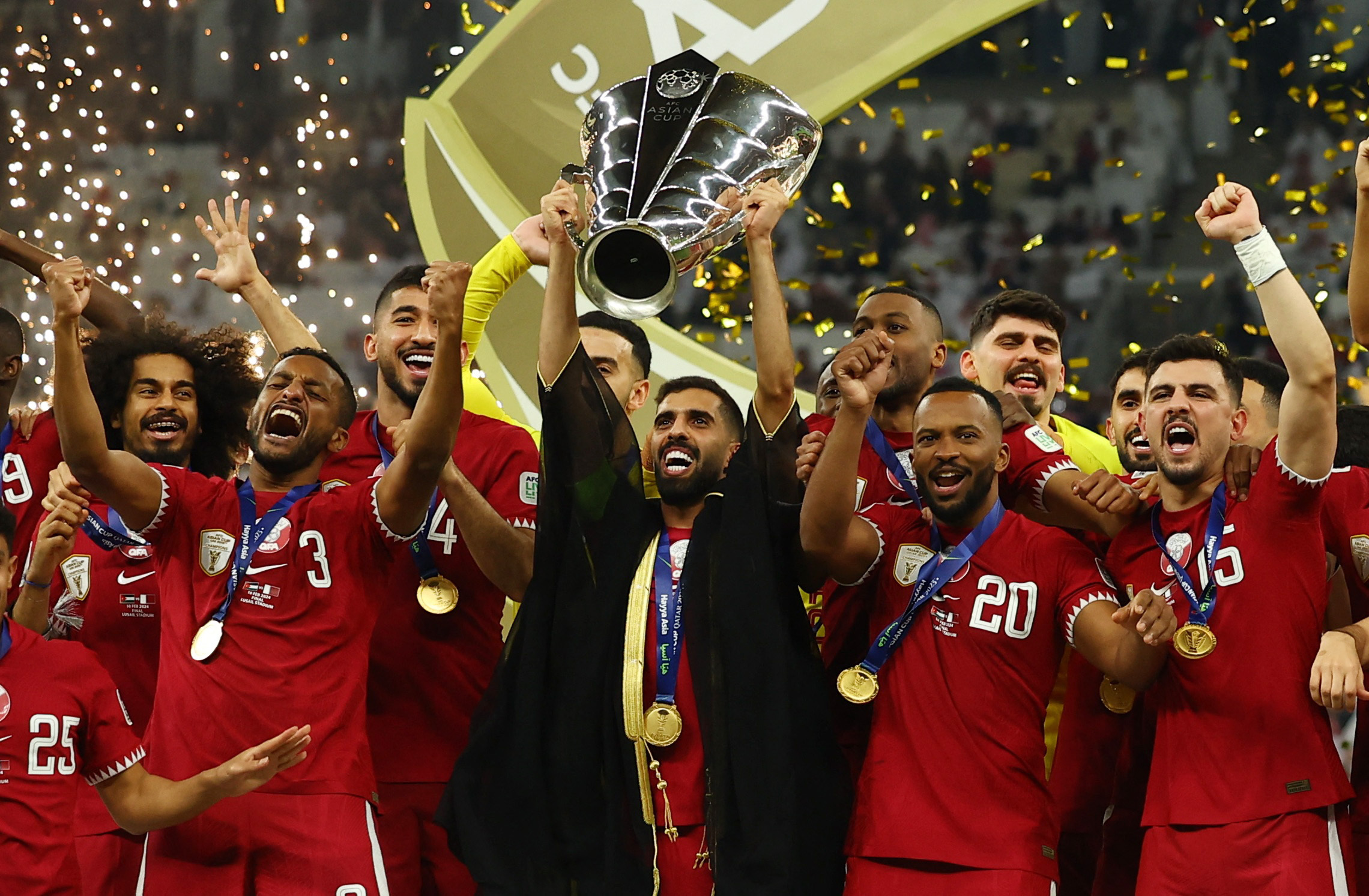Qatar's Hassan Al-Haydos lifts the trophy with teammates after winning the AFC Asian Cup