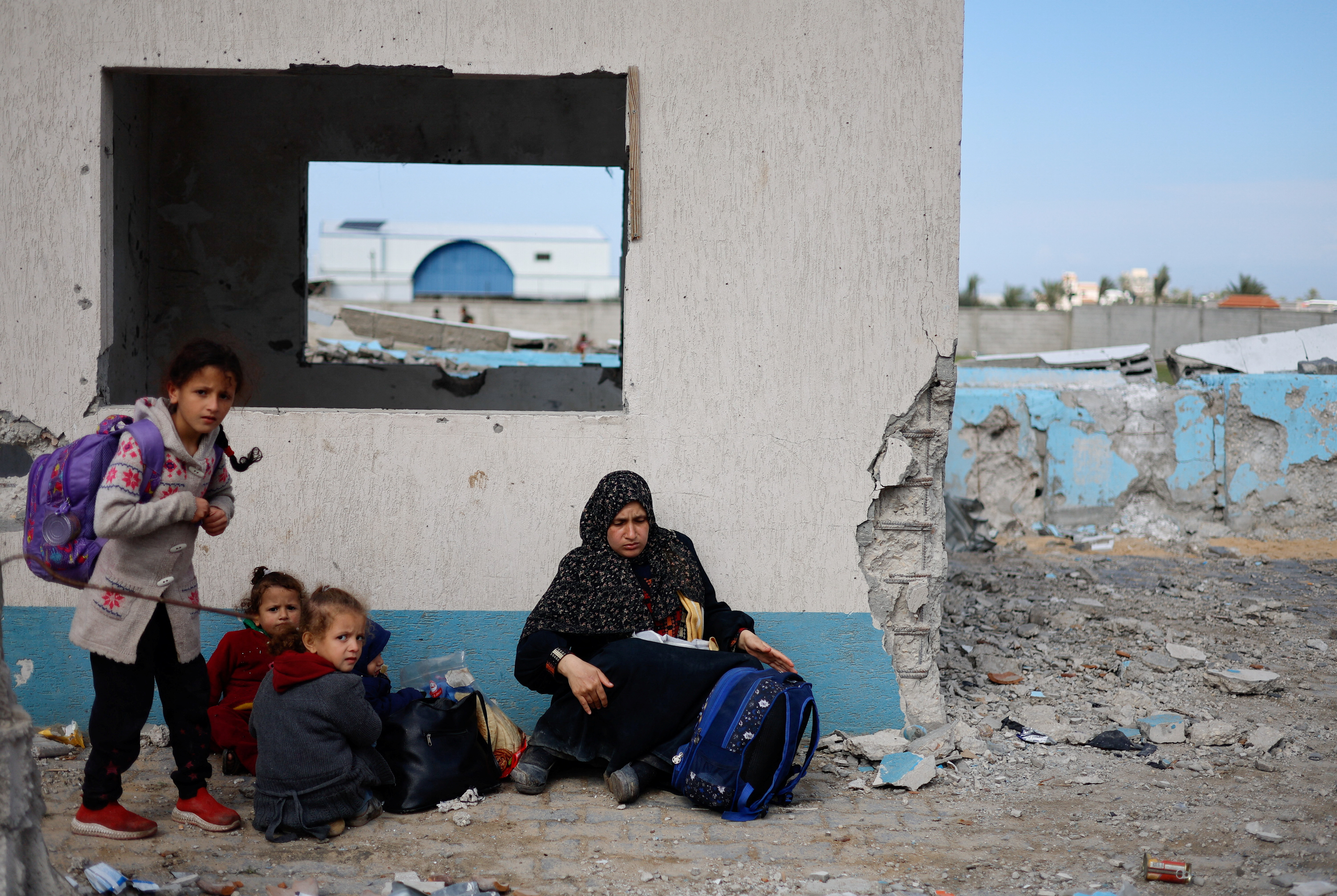 A woman rests with children, as Palestinian arrive in Rafah after they were evacuated from Nasser hospital in Khan Younis due to the Israeli ground operation, amid the ongoing conflict between Israel and Hamas, in the southern Gaza Strip, February 15, 2024. REUTERS/Mohammed Salem