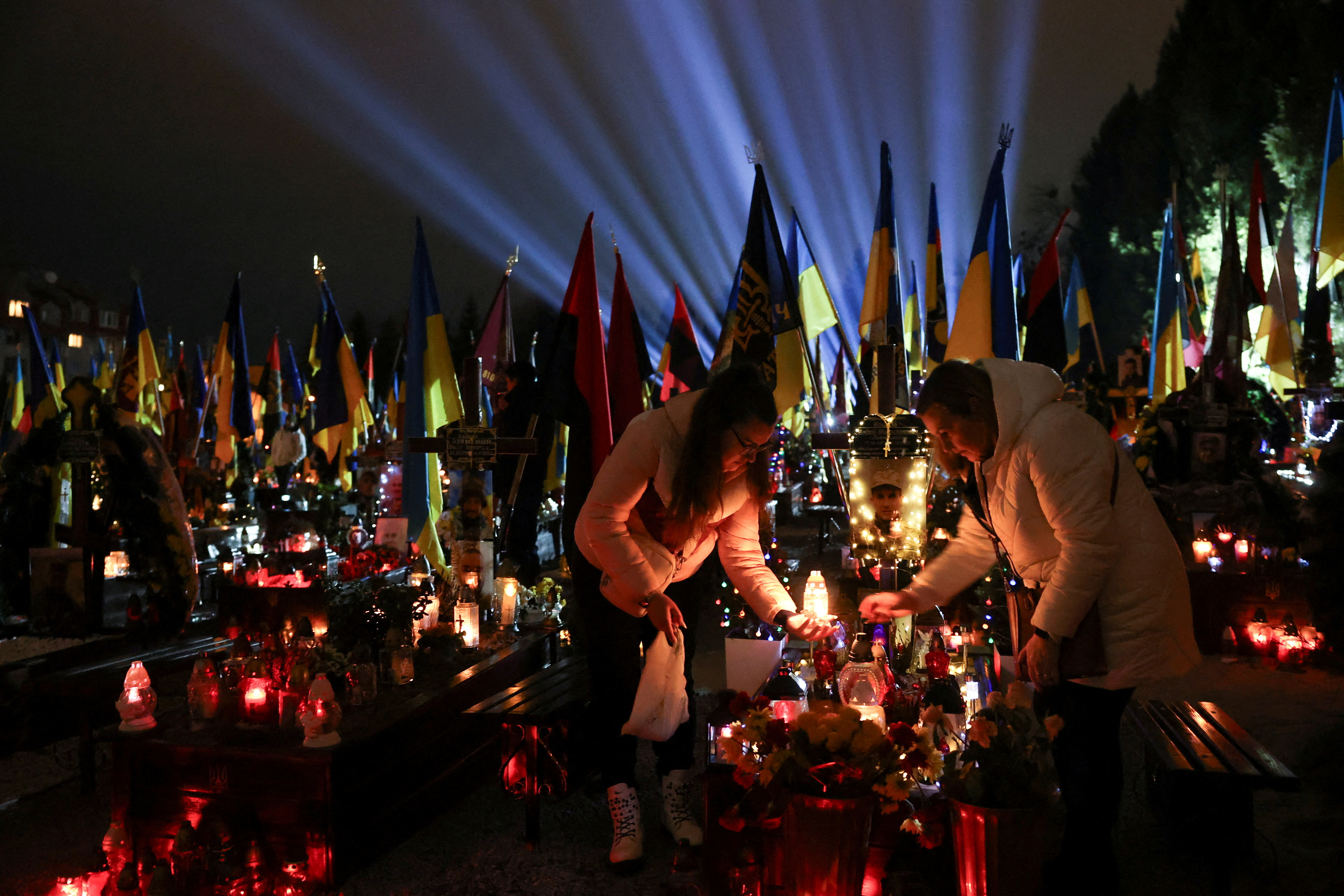 People visit the grave of their relative, a Ukrainian service member killed in a fight against Russian troops, ahead of the second anniversary of Russia's attack on Ukraine, at a military cemetery in Lviv, Ukraine February 23