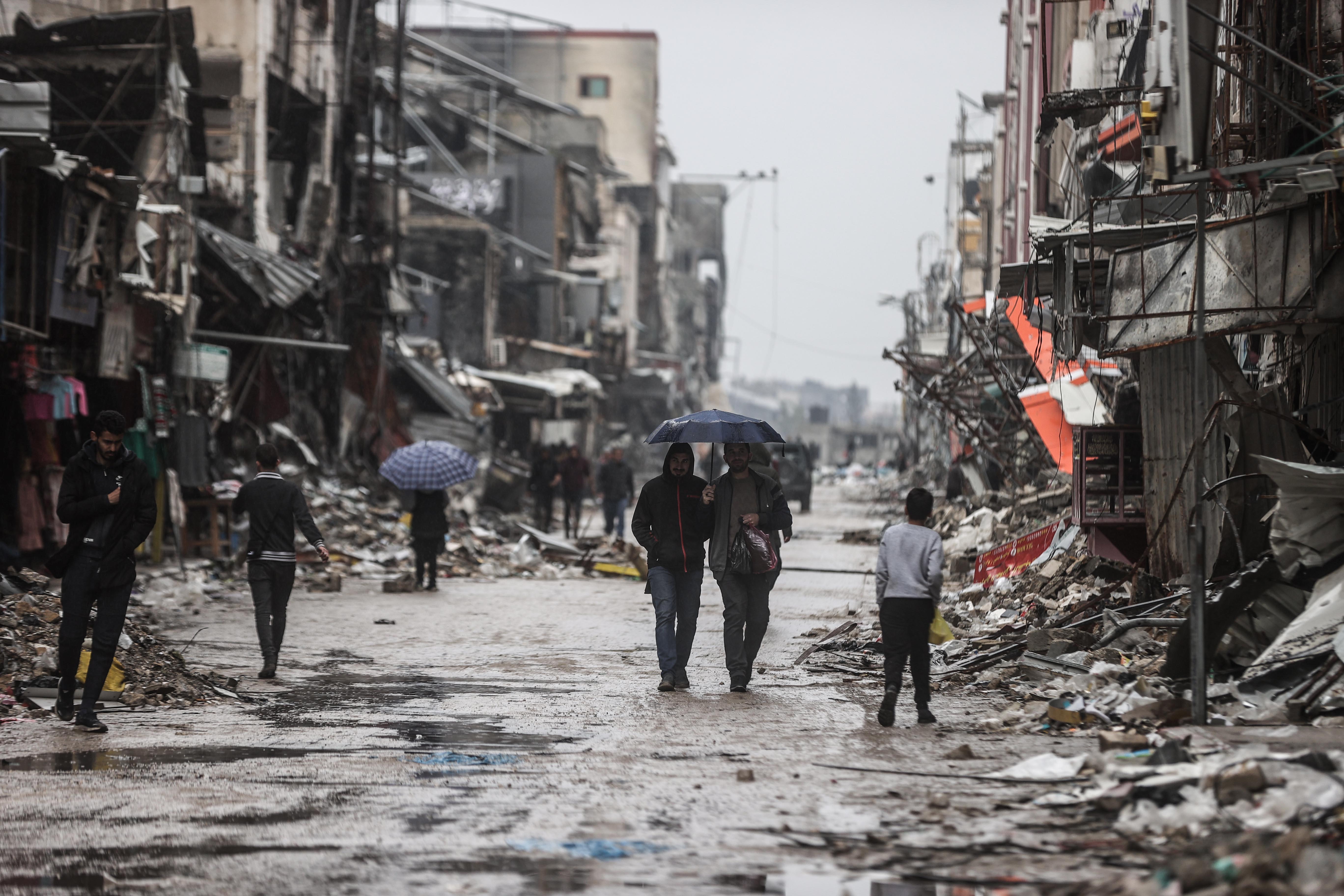People walk amid destruction in Gaza City on January 27