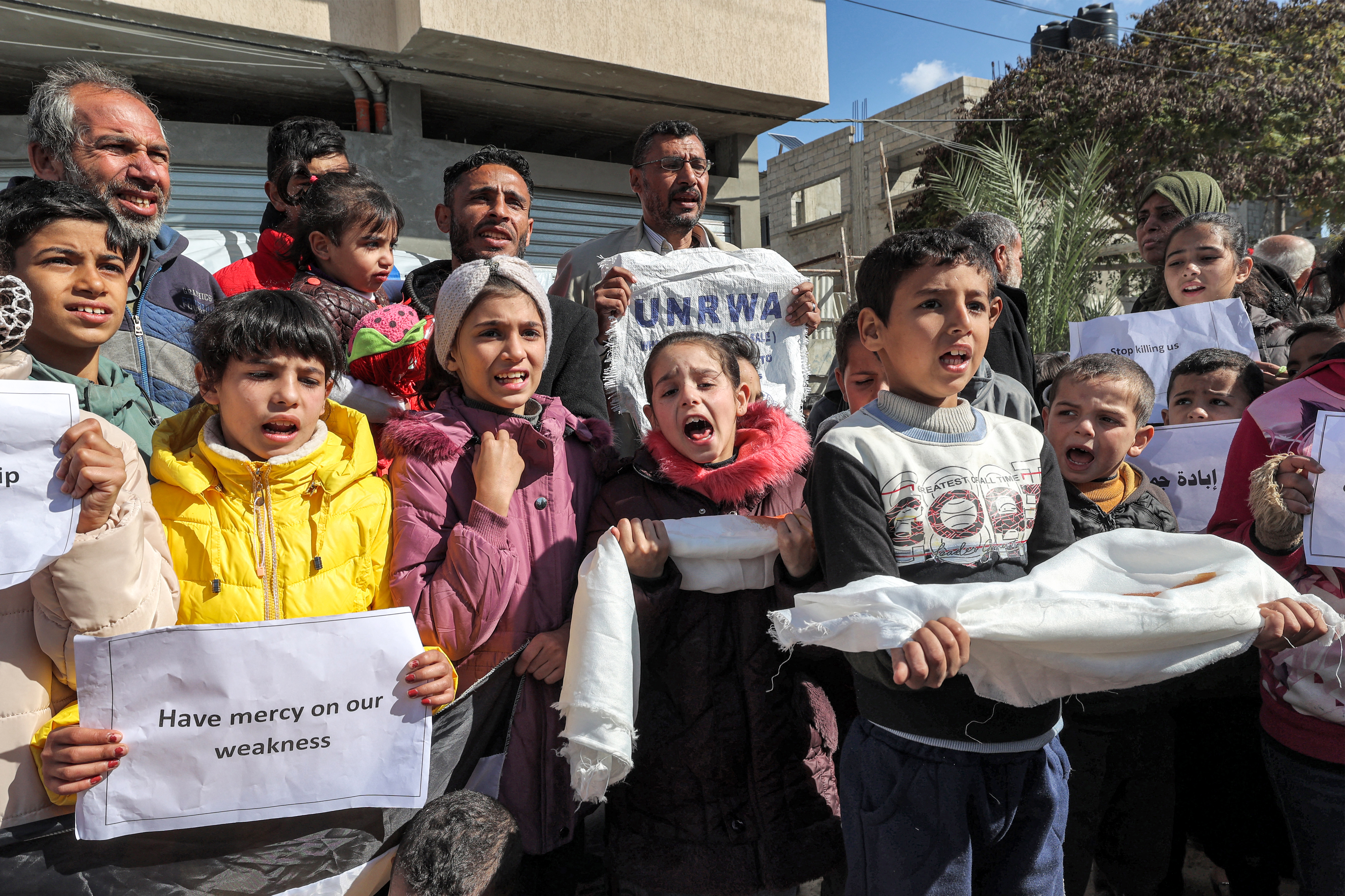 Palestinian men and children gather for a demonstration in Rafah in the southern Gaza Strip on January 30, 2024, calling for continued international support to the United Nations Relief and Works Agency for Palestine Refugees in the Near East (UNRWA) amid the ongoing conflict between Israel and the Palestinian militant group Hamas. - At least 12 countries -- with top donors the United States and Germany joined by New Zealand on January 30 -- have suspended their funding to UNRWA over Israeli claims that some of its staff members were involved in the October 7 attack. (Photo by AFP)
