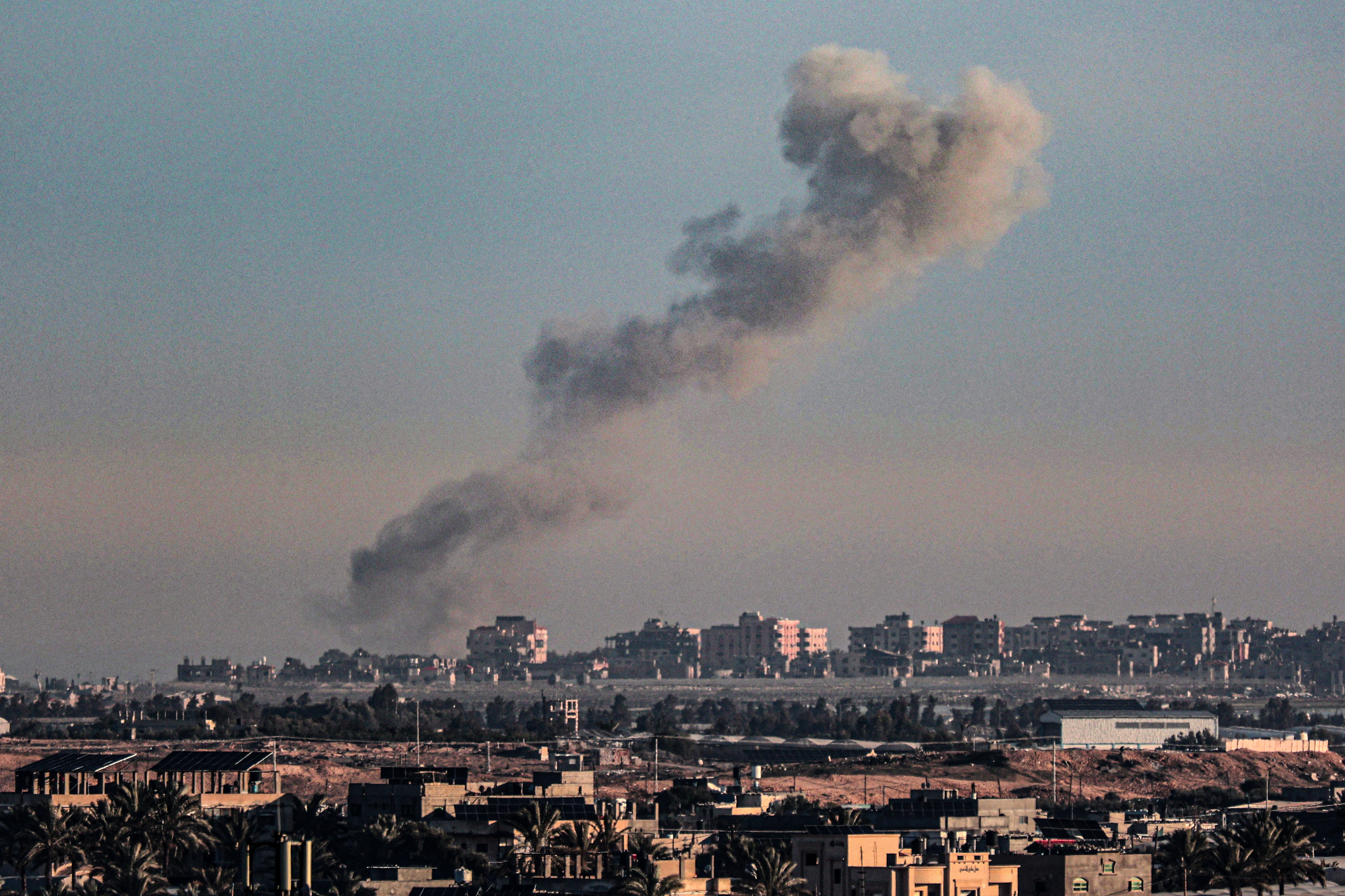 A picture taken from Rafah in the southern Gaza Strip shows smoke rising over buildings in Khan Younis following Israeli bombardment on February 4