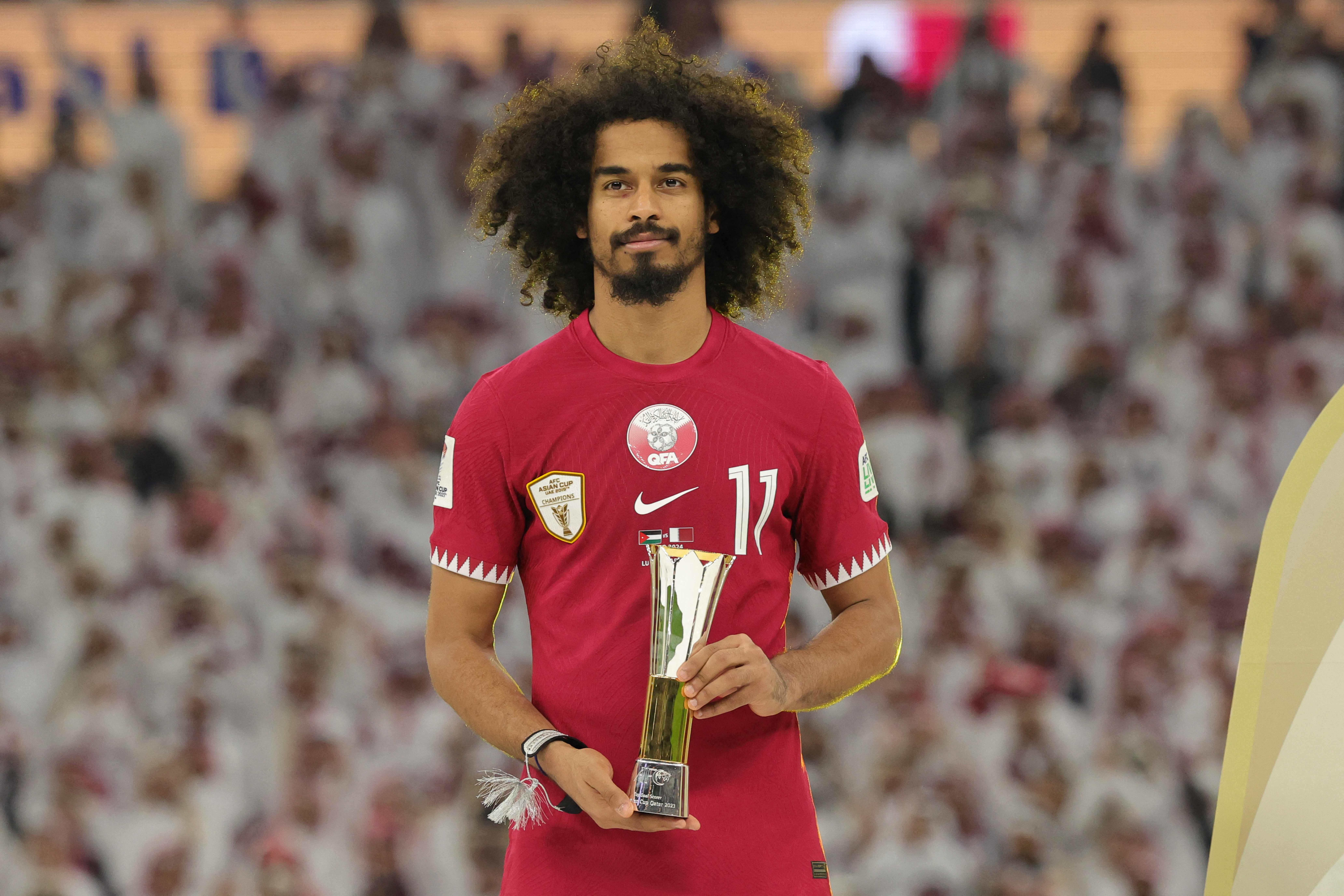Akram Afif celebrates with the Top Goal Scorer Award trophy during the podium ceremony