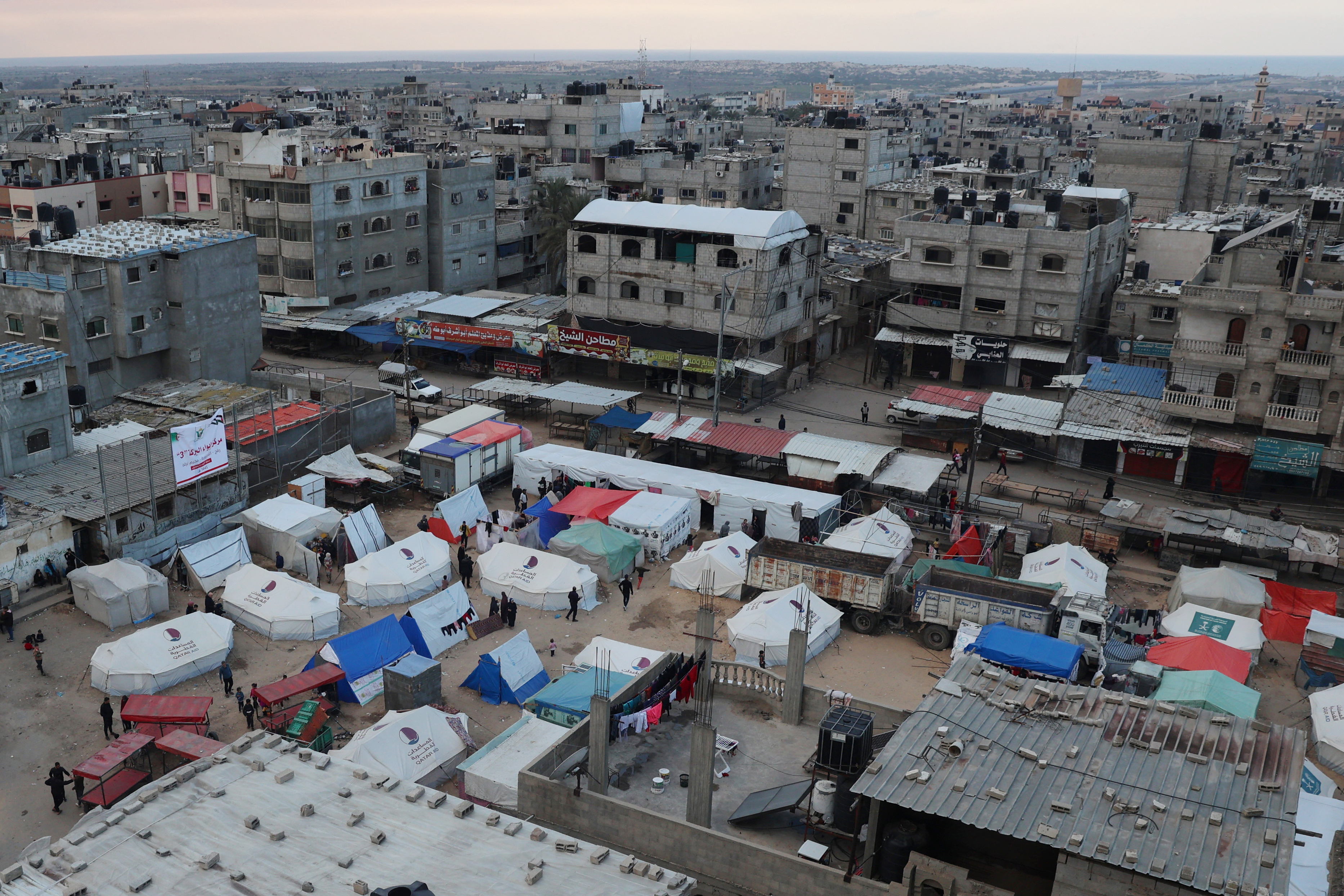 Displaced Palestinians stand outside their tents in Rafah in the southern Gaza Strip on February 14, 2024
