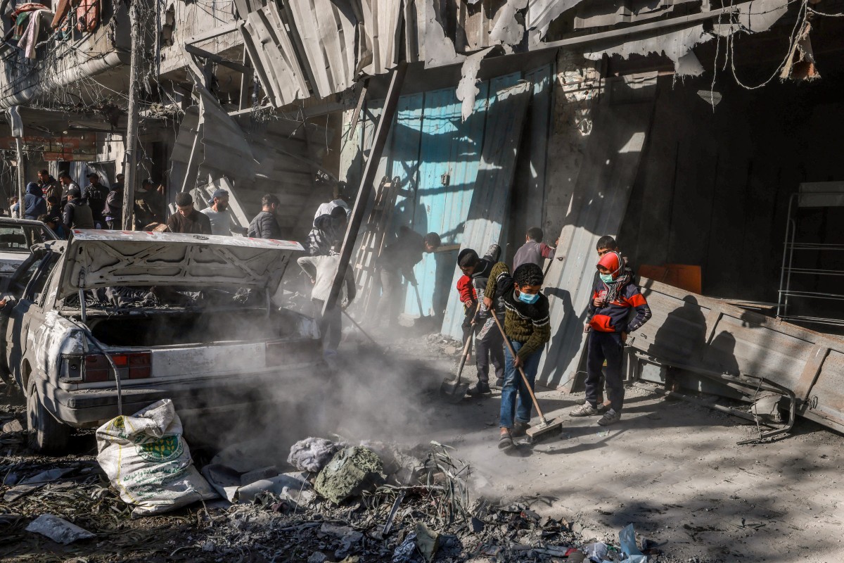 Palestinian children clean debris