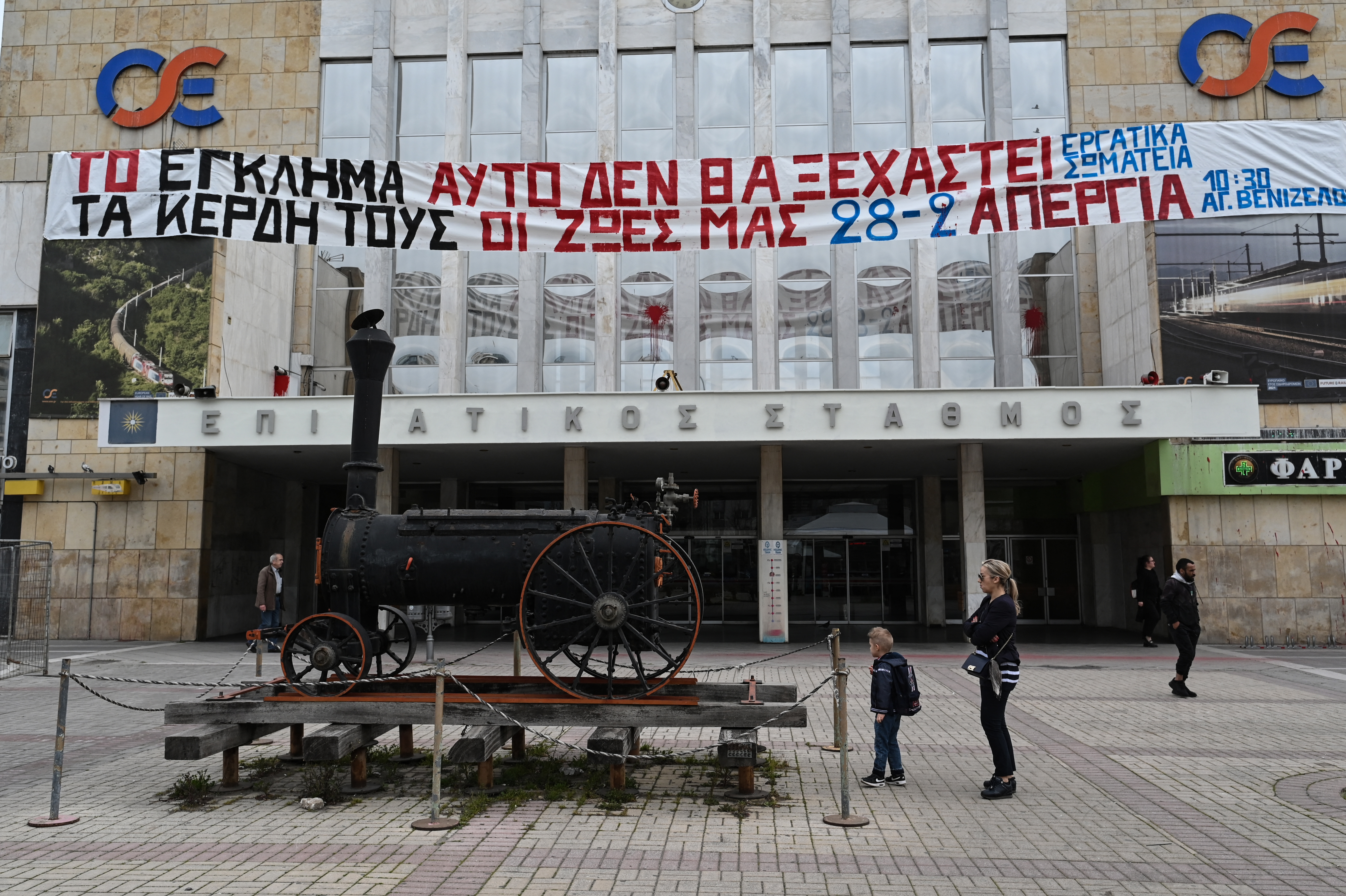 A banner reading "This crime will not be forgotten, their profits our lives" outside the central train station of Thessaloniki during a 24-hour strike on February 28, 2024