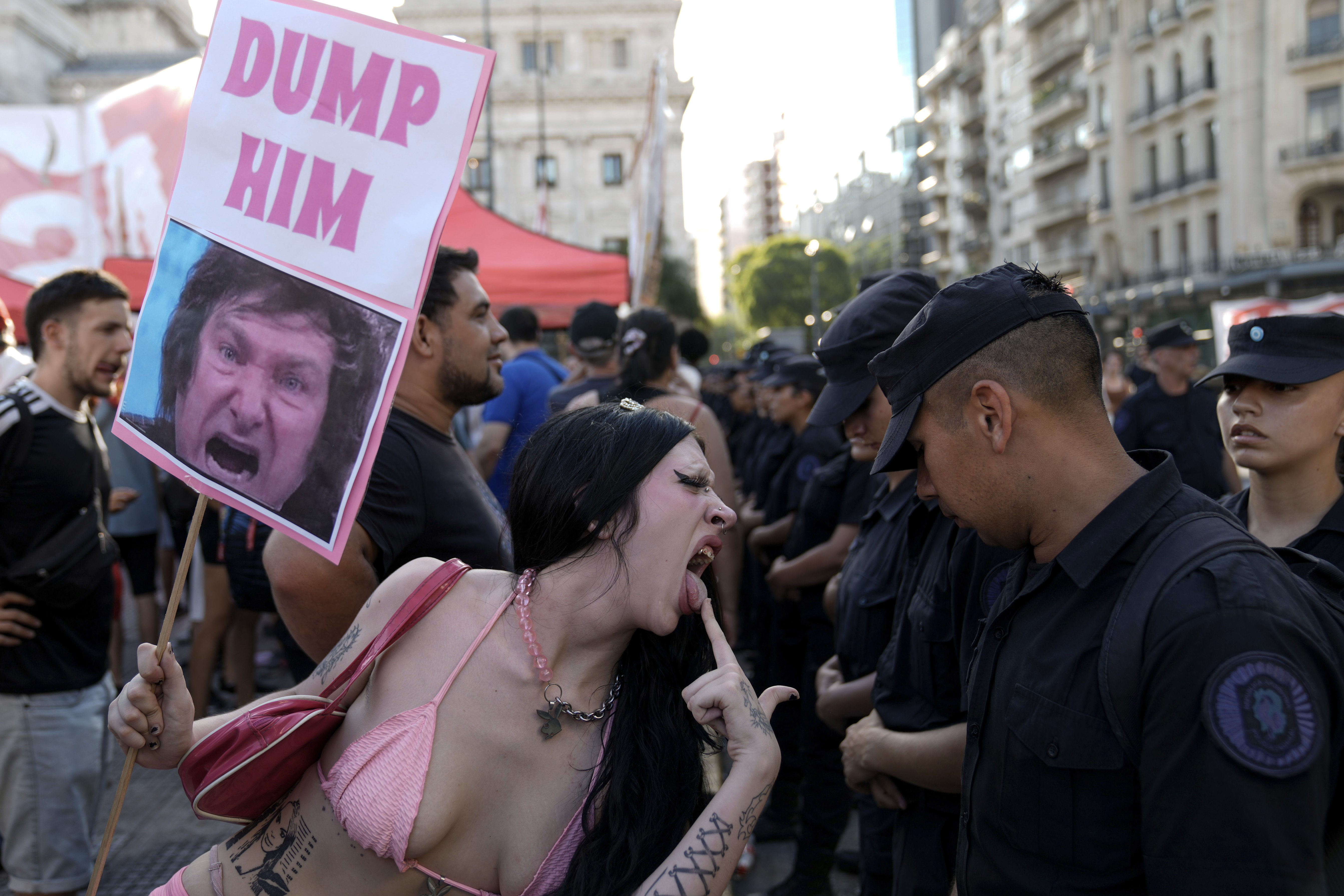 An anti-government protester taunts police guarding Congress where lawmakers are debating a bill promoted by Argentine President Javier Milei, in Buenos Aires, Argentina, Thursday, Feb. 1