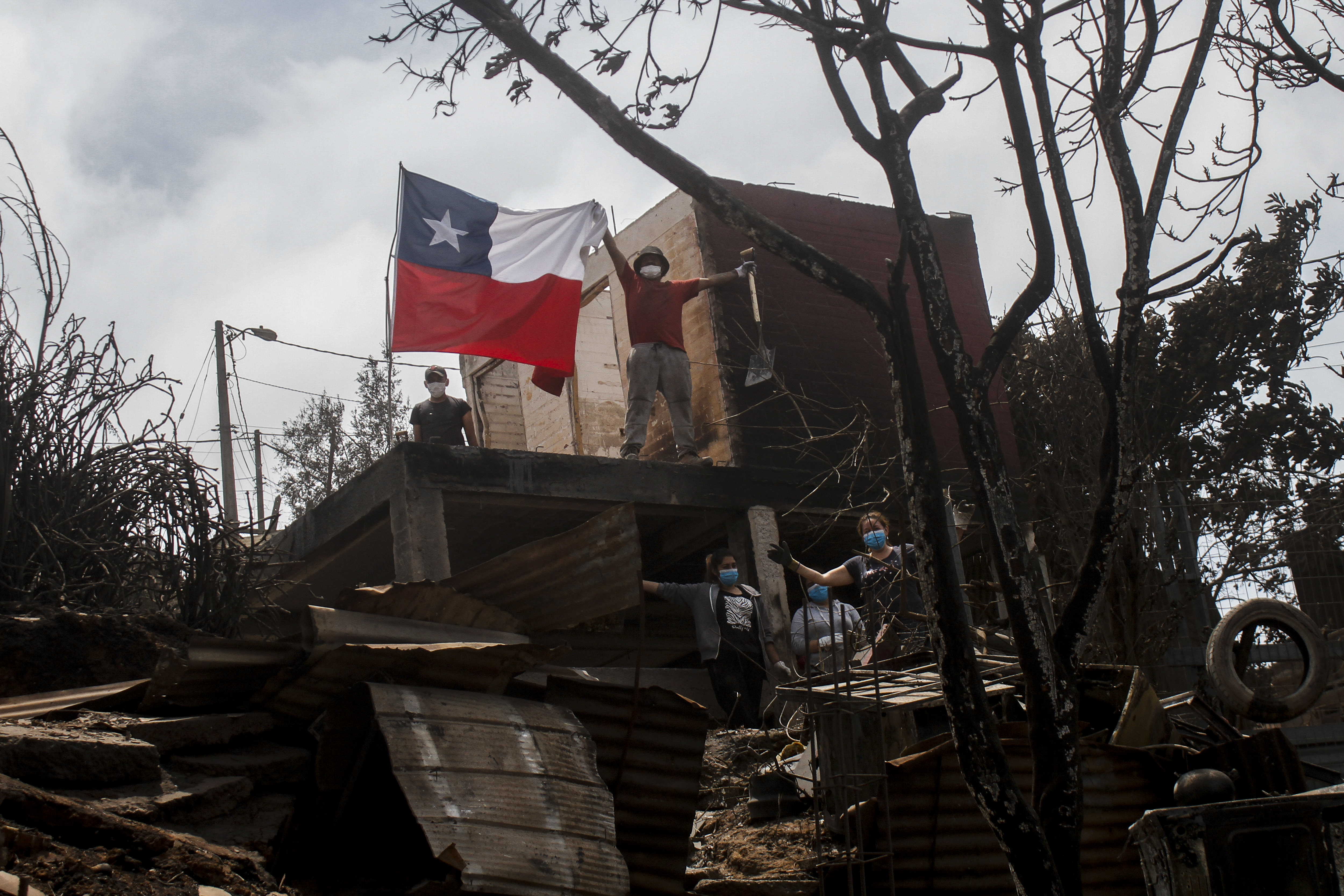 A resident poses displays a Chilean flag