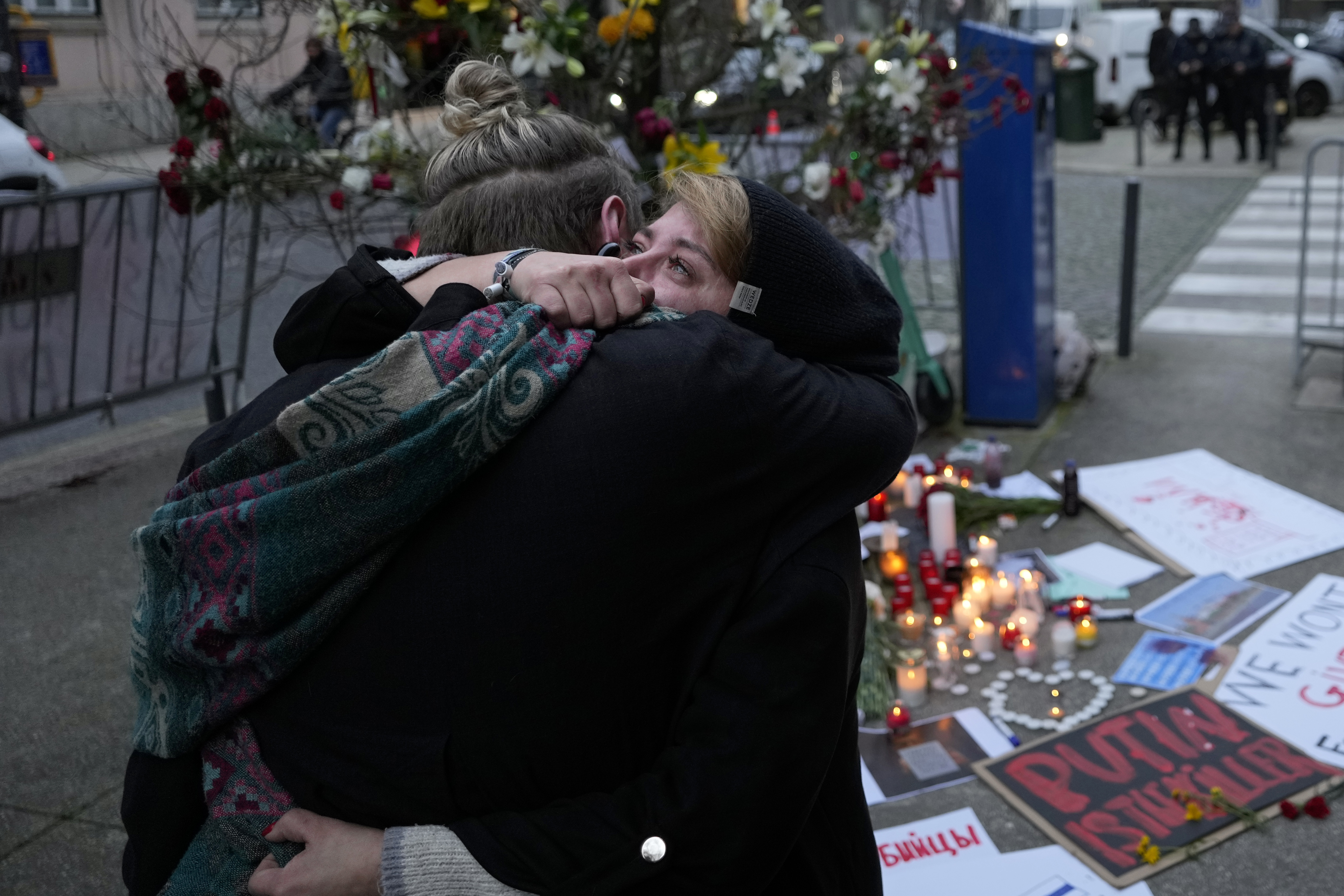 Two women hug as they meet in front of the Russian embassy in Lisbon during a vigil for Russian opposition leader Alexei Navalny, Friday, Feb. 16