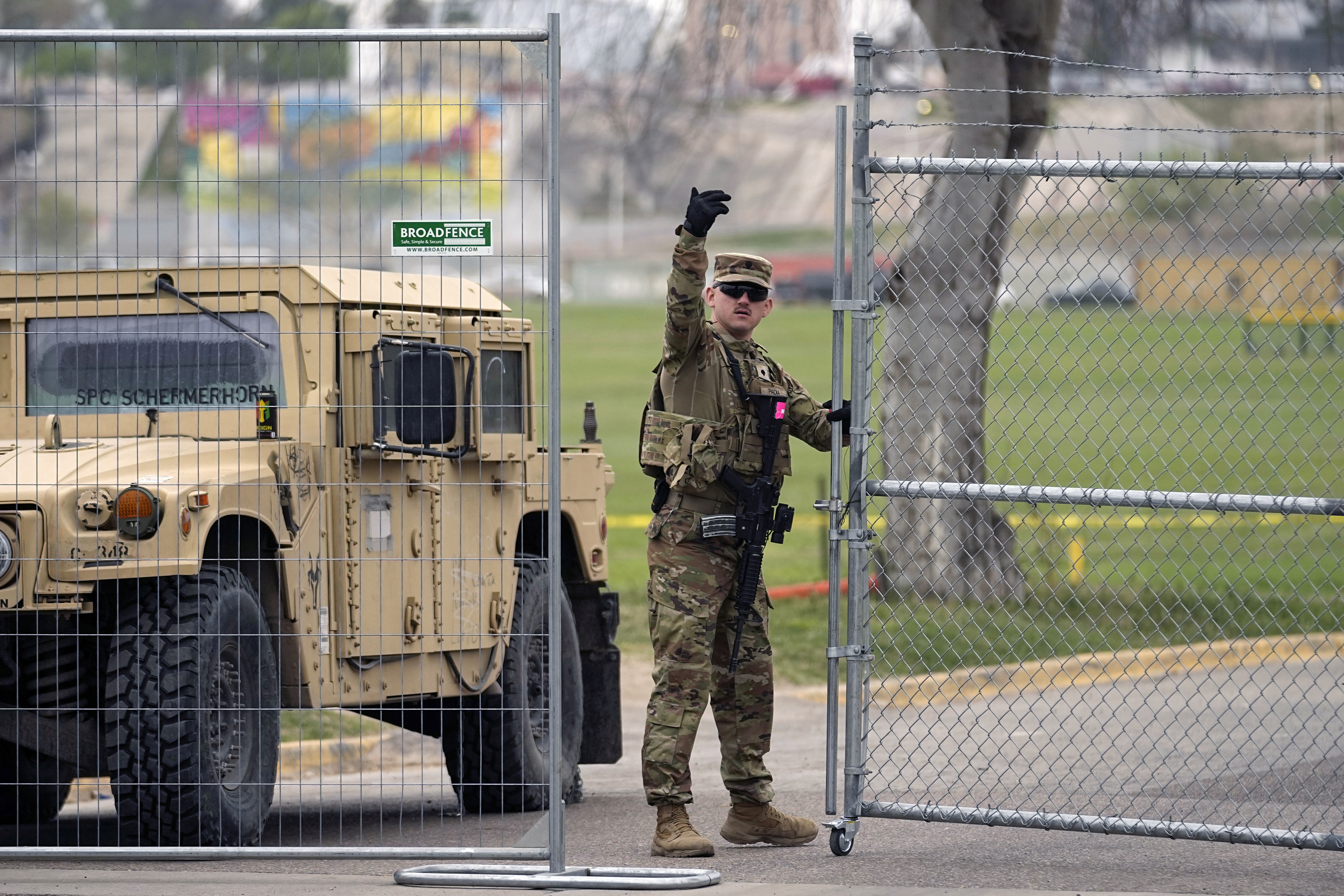 A member of the National Guard directs a vehicle at the gate to Shelby Park along the Rio Grande