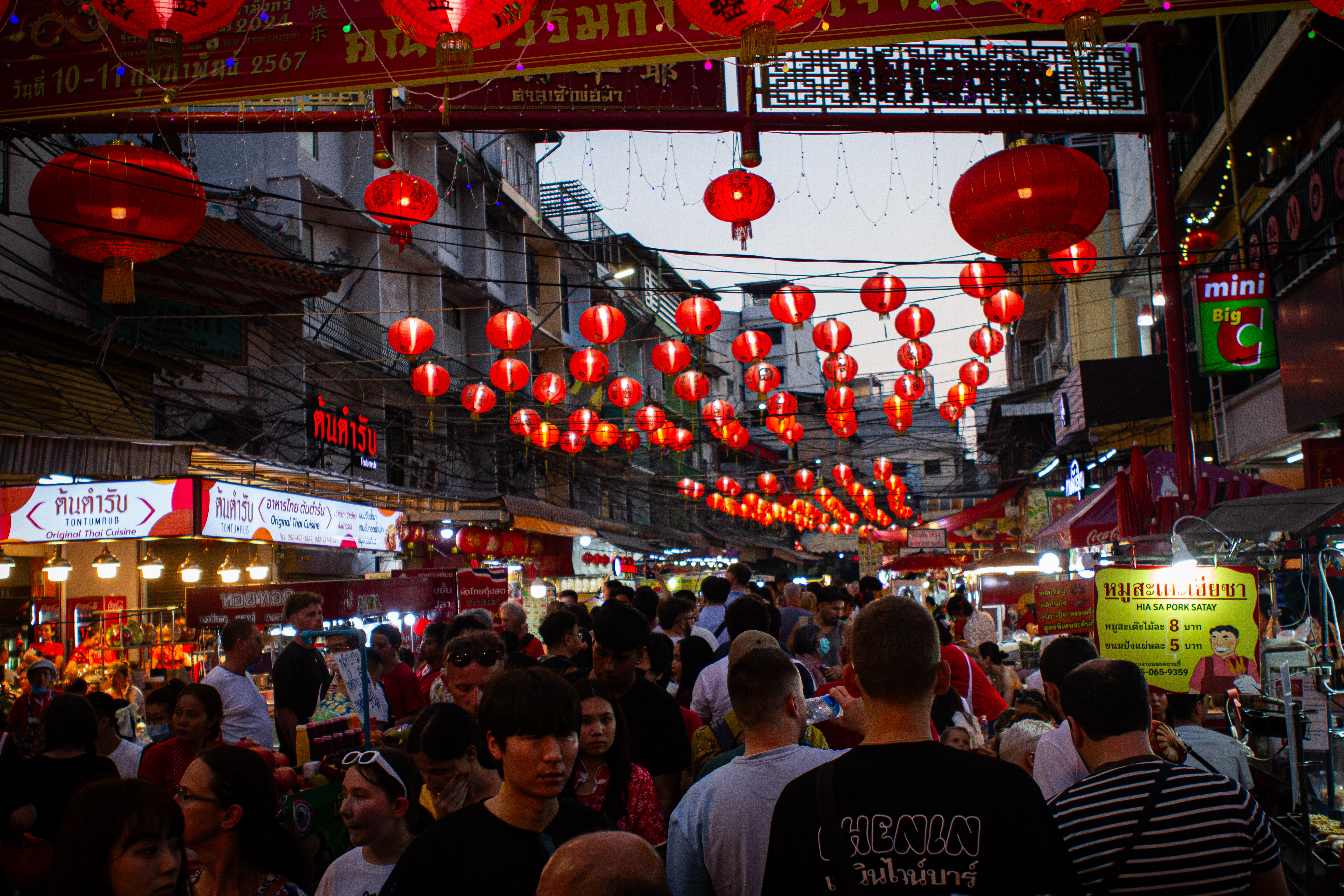 Crowds along the streets in Bangkok, Chinese lanterns have been strung across the road