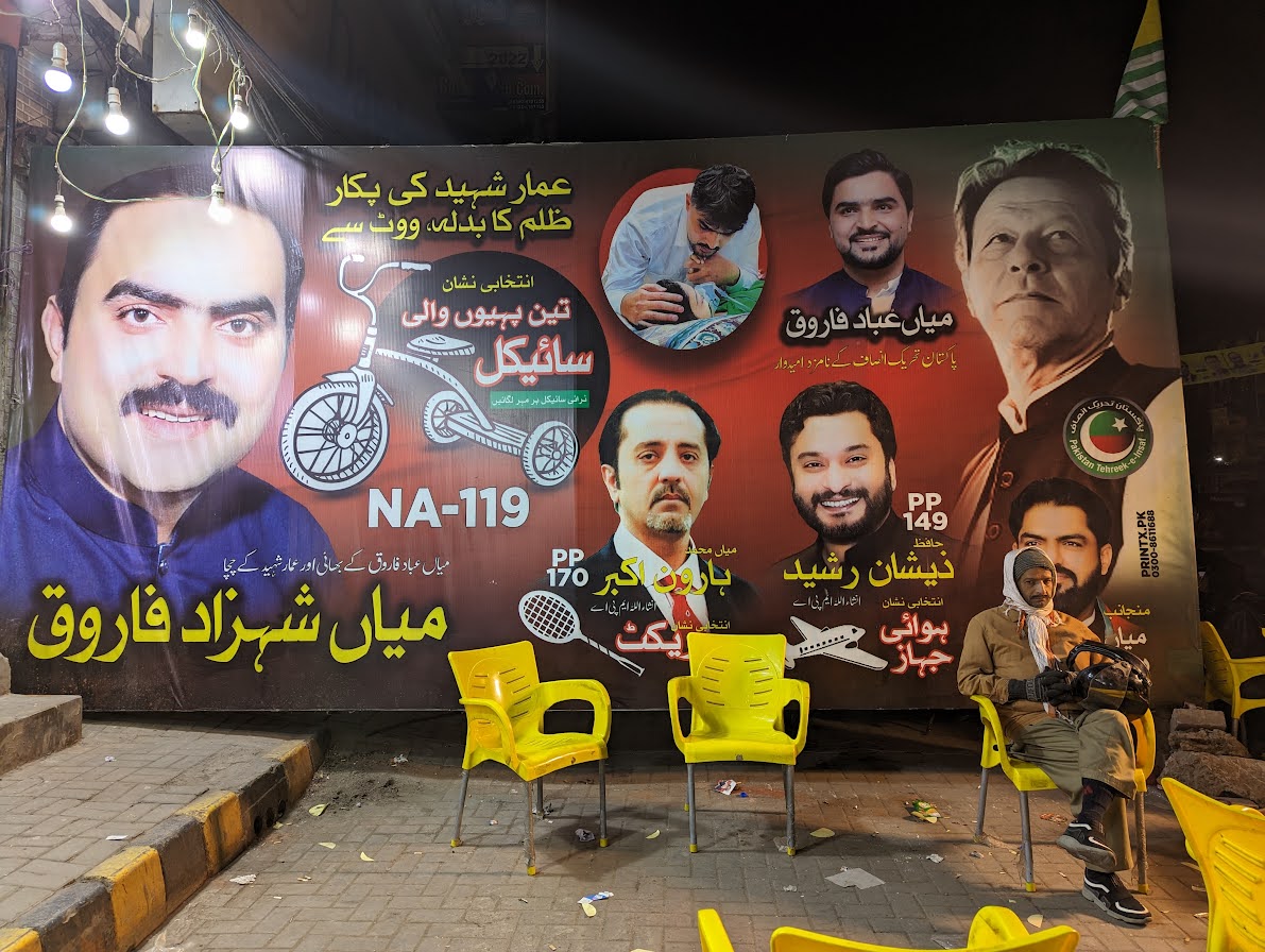 A lone person sitting at a PTI camp in Lahore.